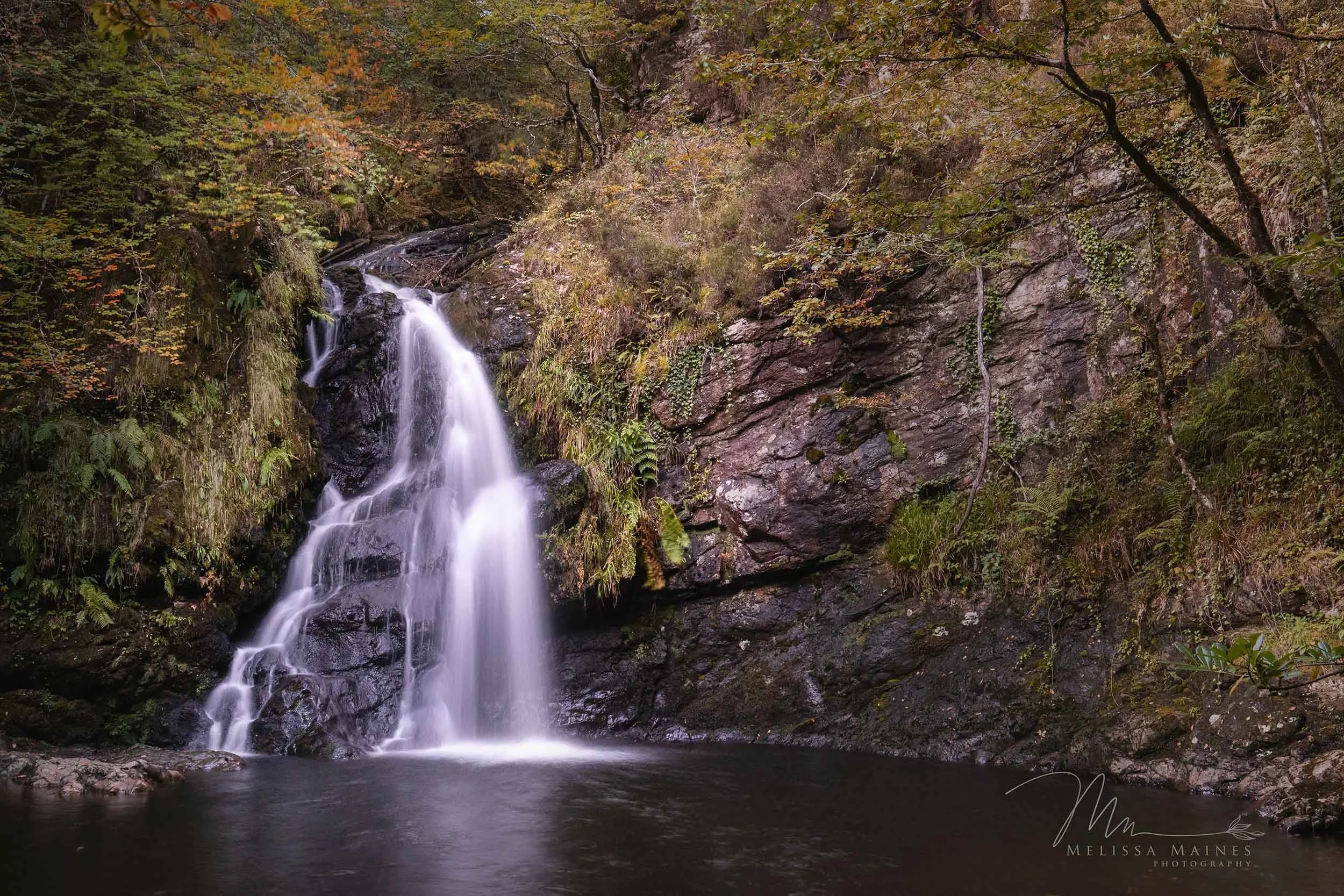 The peaceful Tourmakeady waterfall cascading into a calm pool in County Mayo, Ireland.