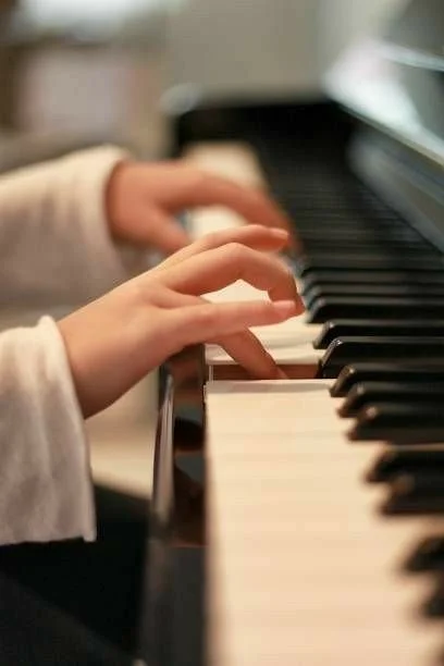 A child's hands playing a piano.