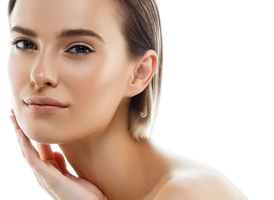 Nahaufnahme eines jungen, hübschen Mädchens mit natürlichem Make-up und glatter, heller Haut, die sanft an ihrem Kinn berührt.