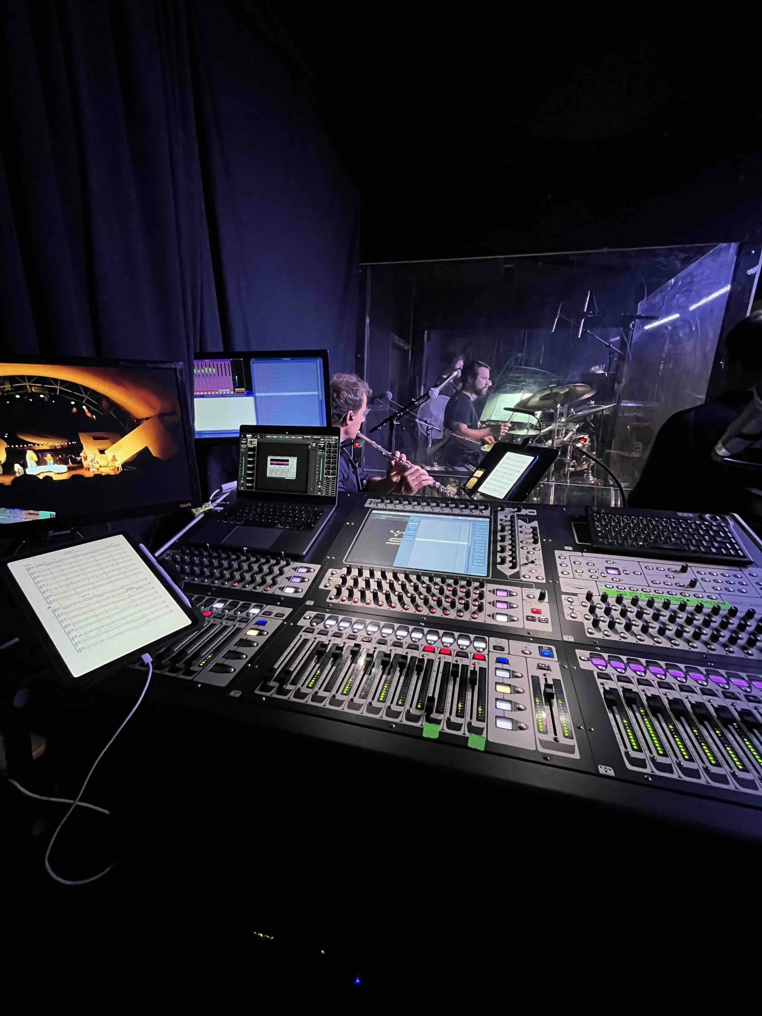 Aufnahme eines Digico Tonpults am Monitorplatz auf einer Bühne mit Musikern im Hintergrund bei einem Live-Konzert.