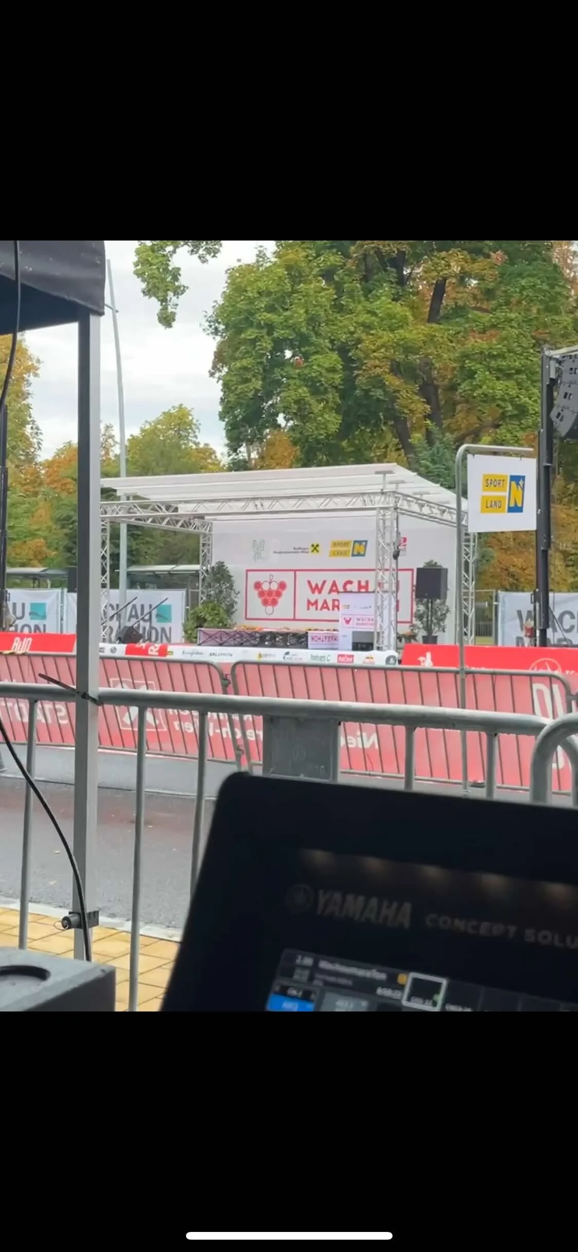 Bühne des Wachau Marathons, umgeben von Absperrungen, im Freien mit Bäumen im Hintergrund.