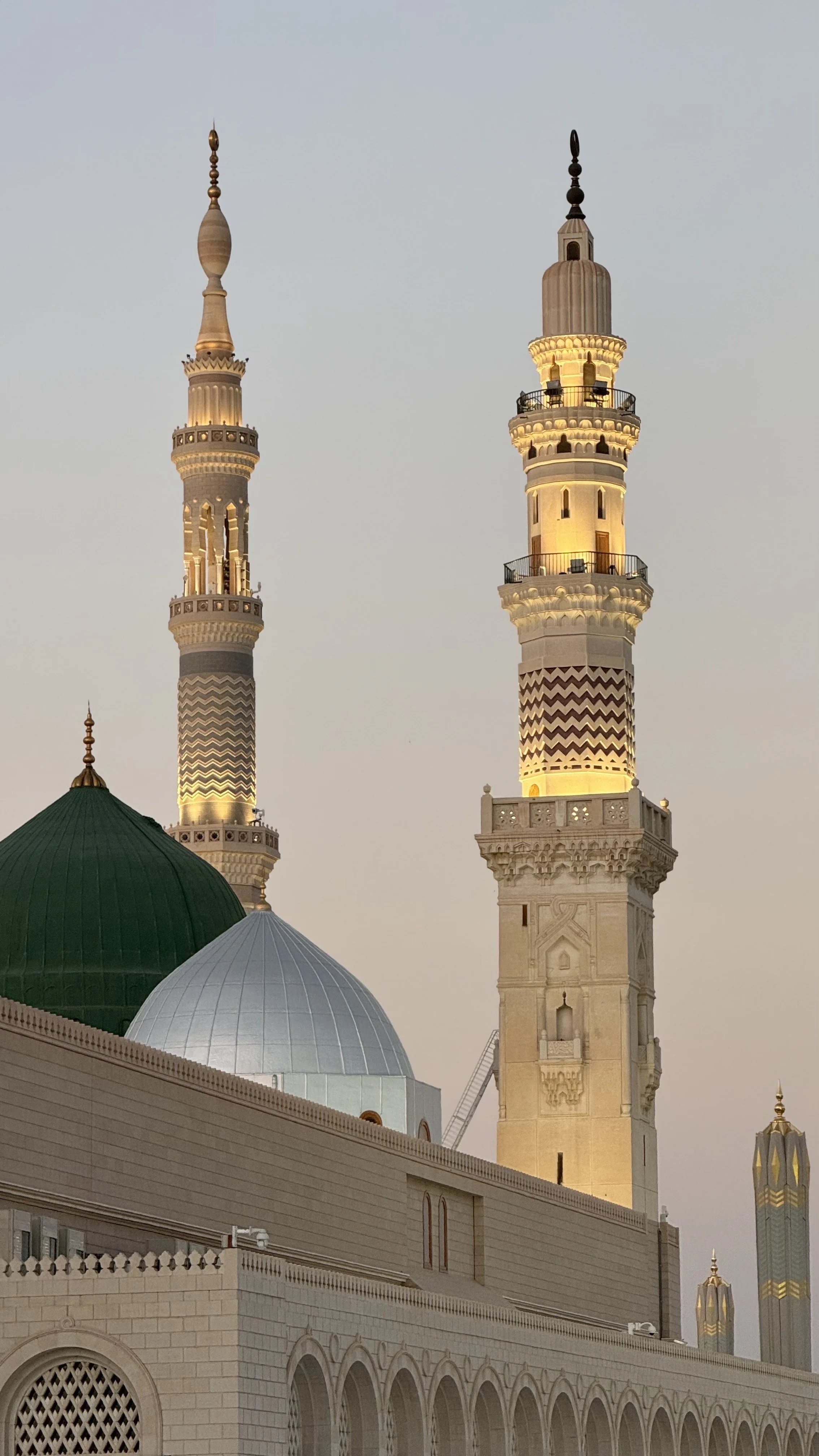 Les minarets et dômes du Masjid al-Haram à La Mecque, éclairés au crépuscule.