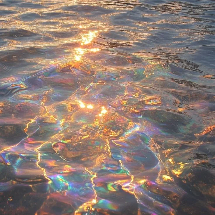 Rainbow colored water with light reflecting off its surface