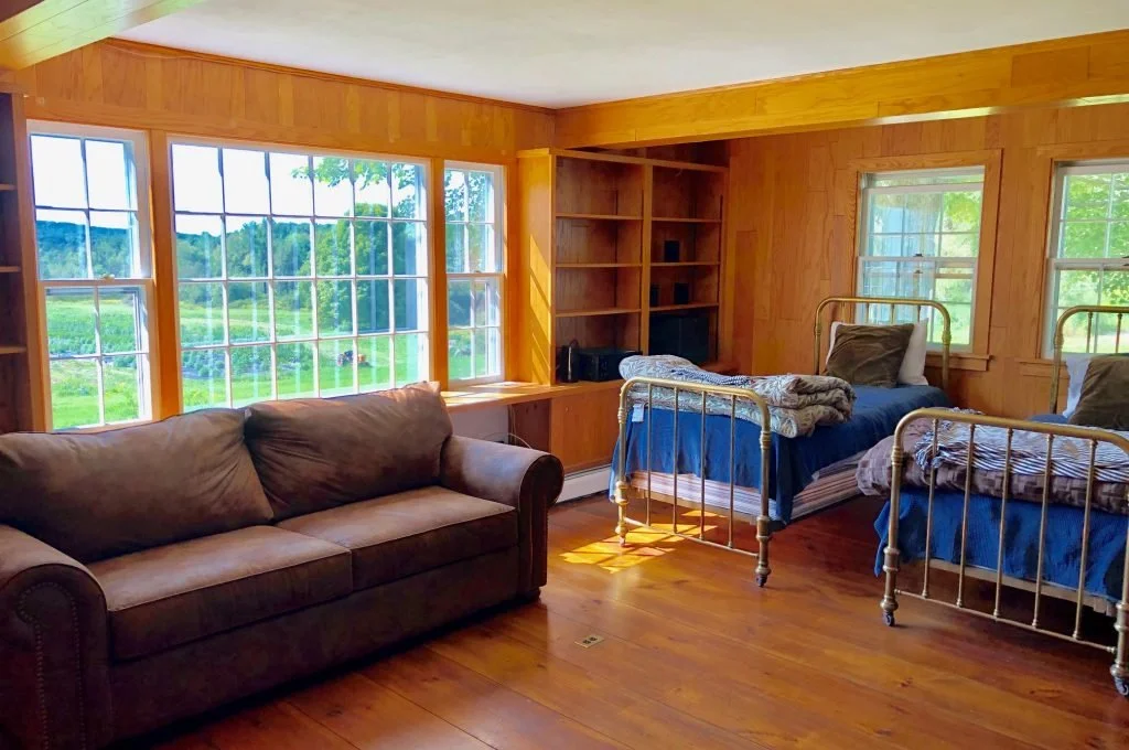 This versatile room can function as a bedroom or second living room. The room contains two single beds and bunk beds. It also has a wood burning fireplace. A full-bathroom is located just outside of the room.