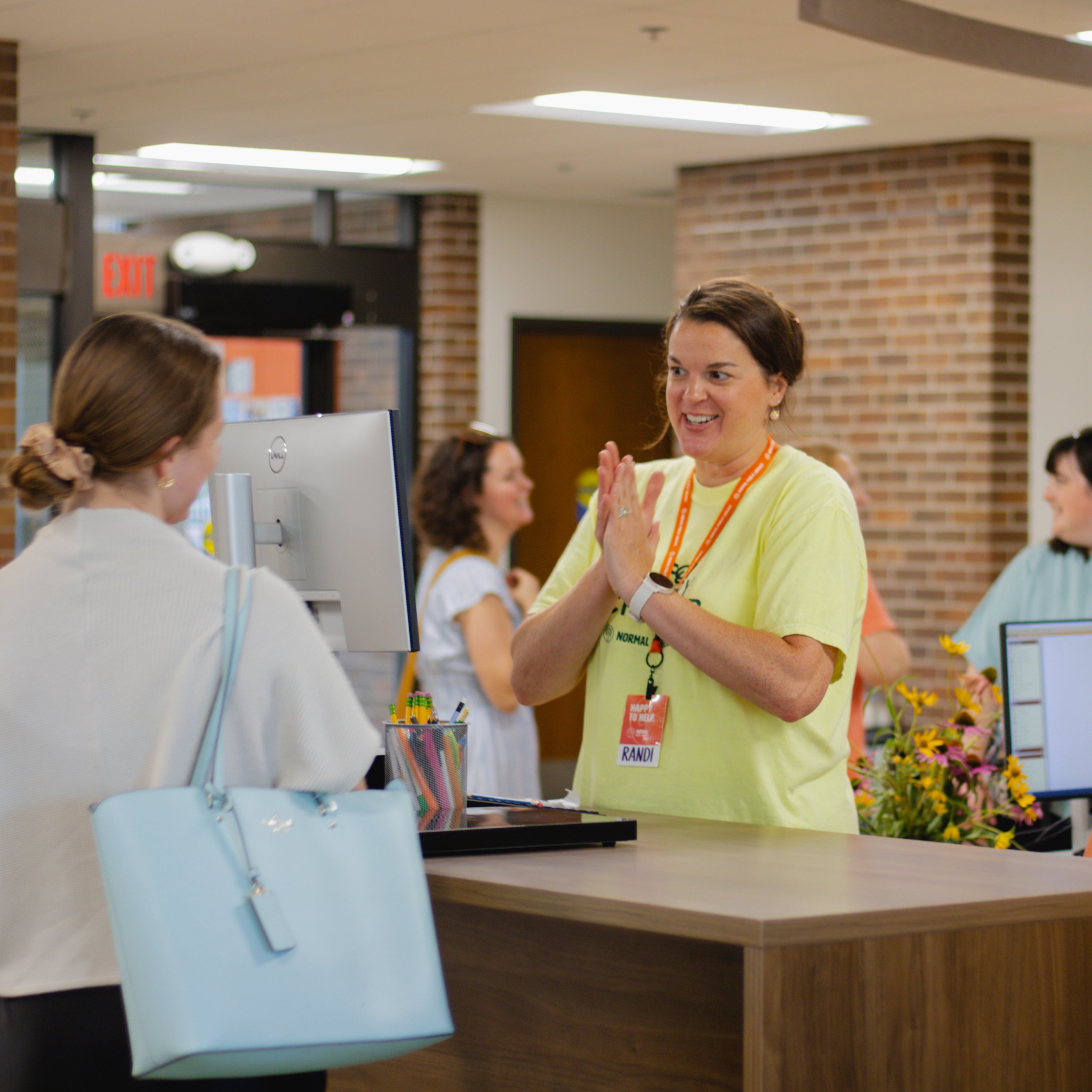 Library employee chatting with a patron at the main desk.