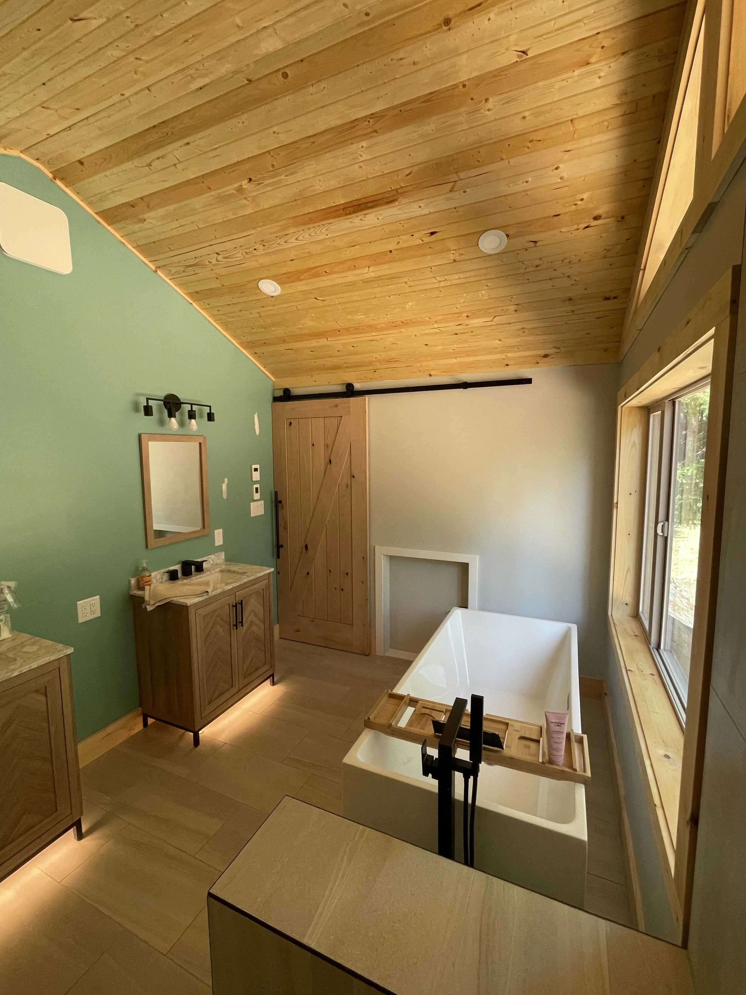 Spa-Inspired Bathroom
This serene bathroom showcases warm wood tones, a sloped ceiling, and a freestanding soaking tub for a spa-like experience. Thoughtful details—like the floating vanity, soft ambient lighting, and natural materials—create a calm,