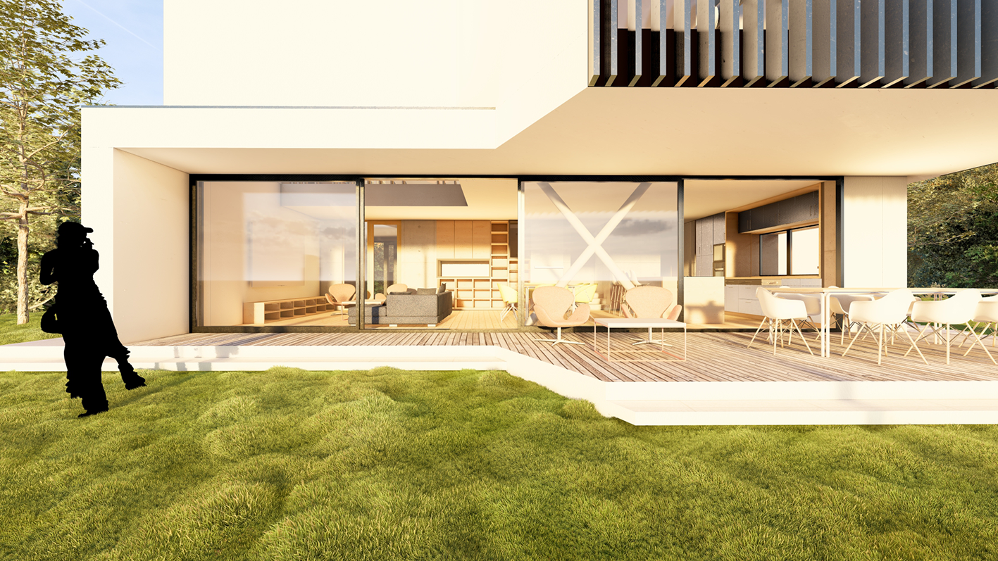 Maison moderne avec une grande terrasse en bois, meubles de jardin et intérieur visible à travers des fenêtres en verre, avec un jardin vert et un arbre à gauche.