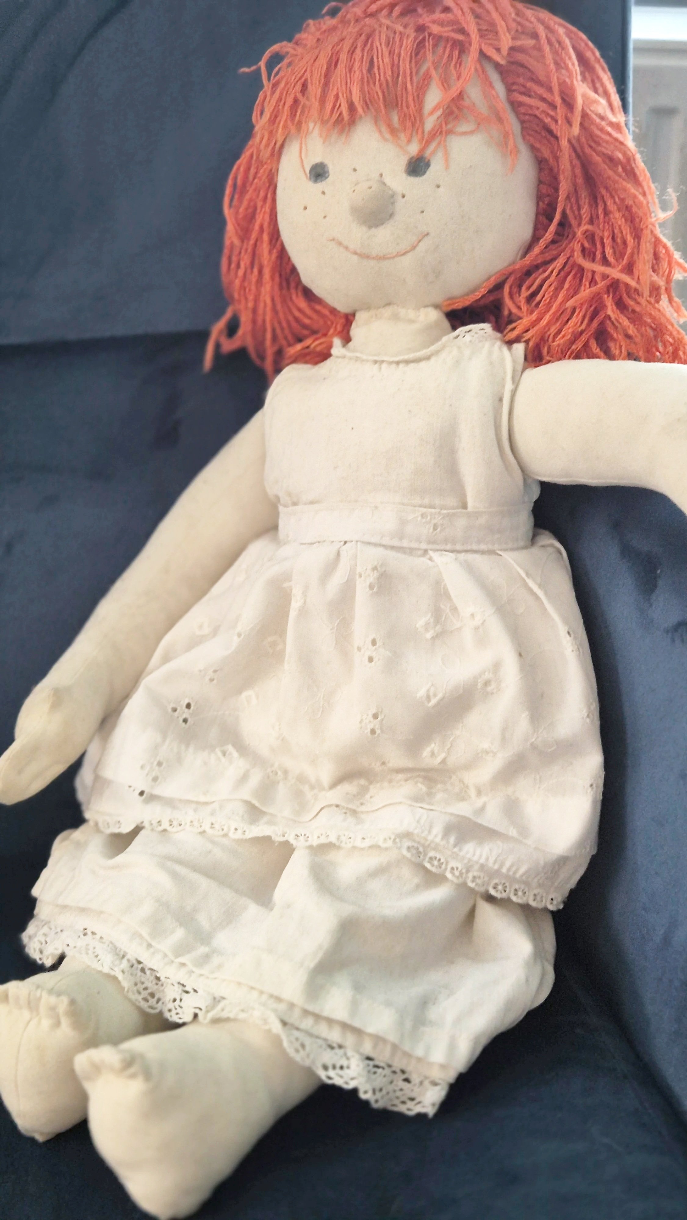 stoffen pop met oranje wollen haar en witte broderie onderjurk en lange onderbroek