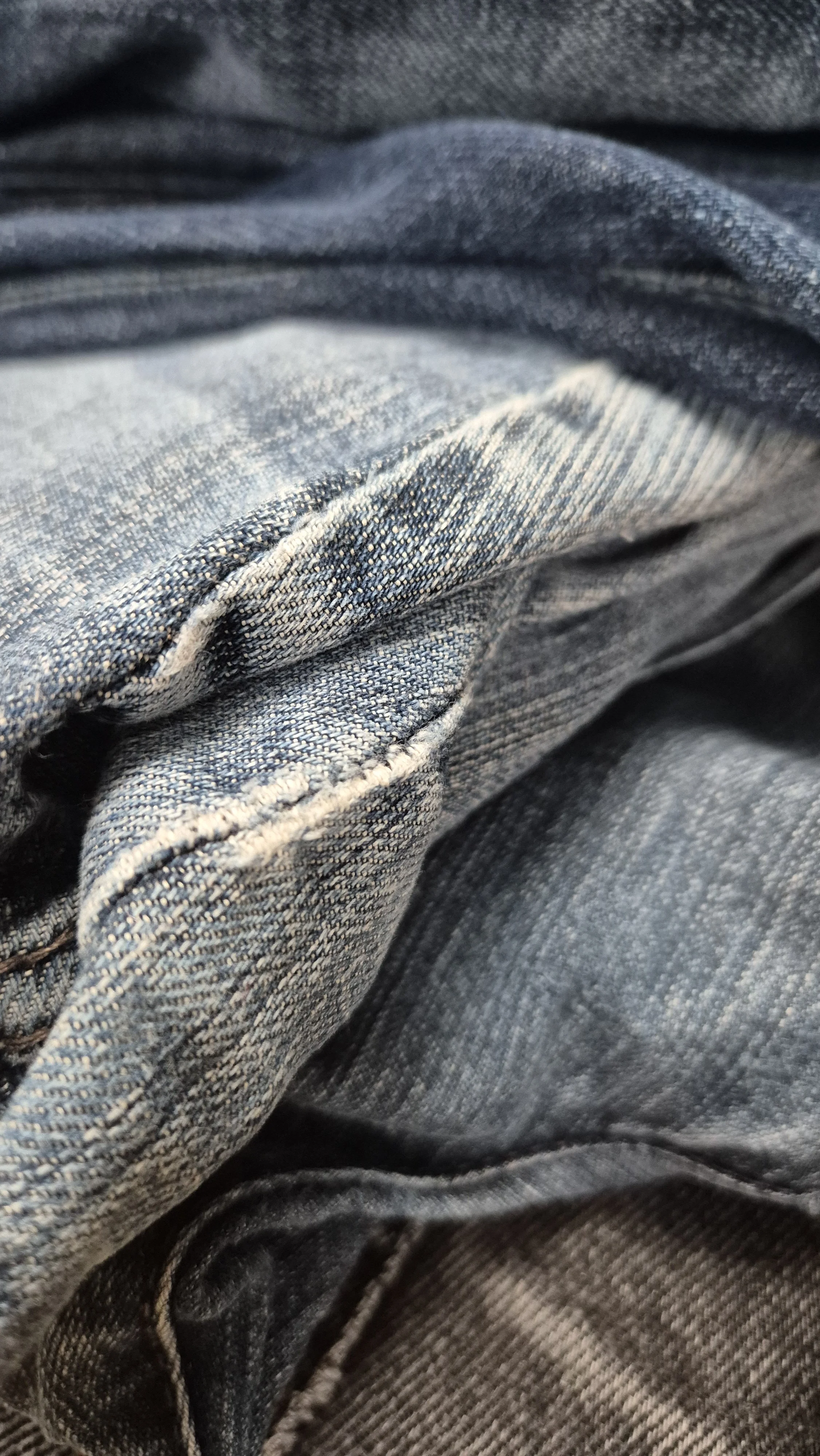 stapeltje oude jeans wachtend op nieuwe kans recycling