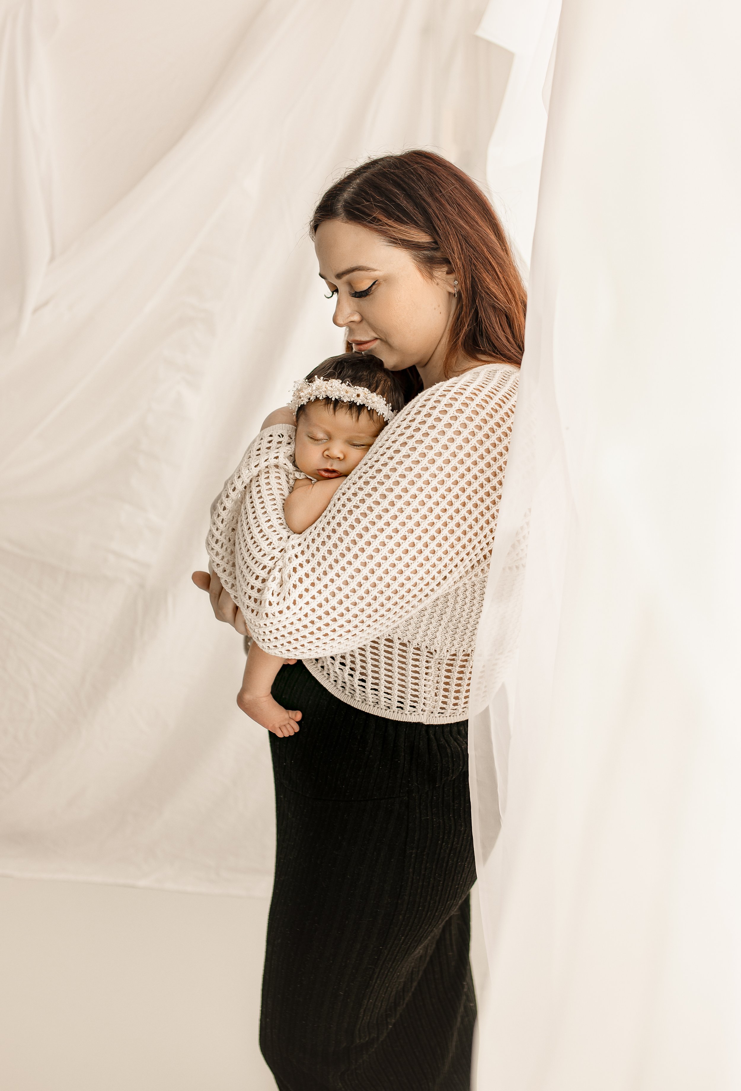 A newborn and new mom in a lifestyle photography studio in Austin