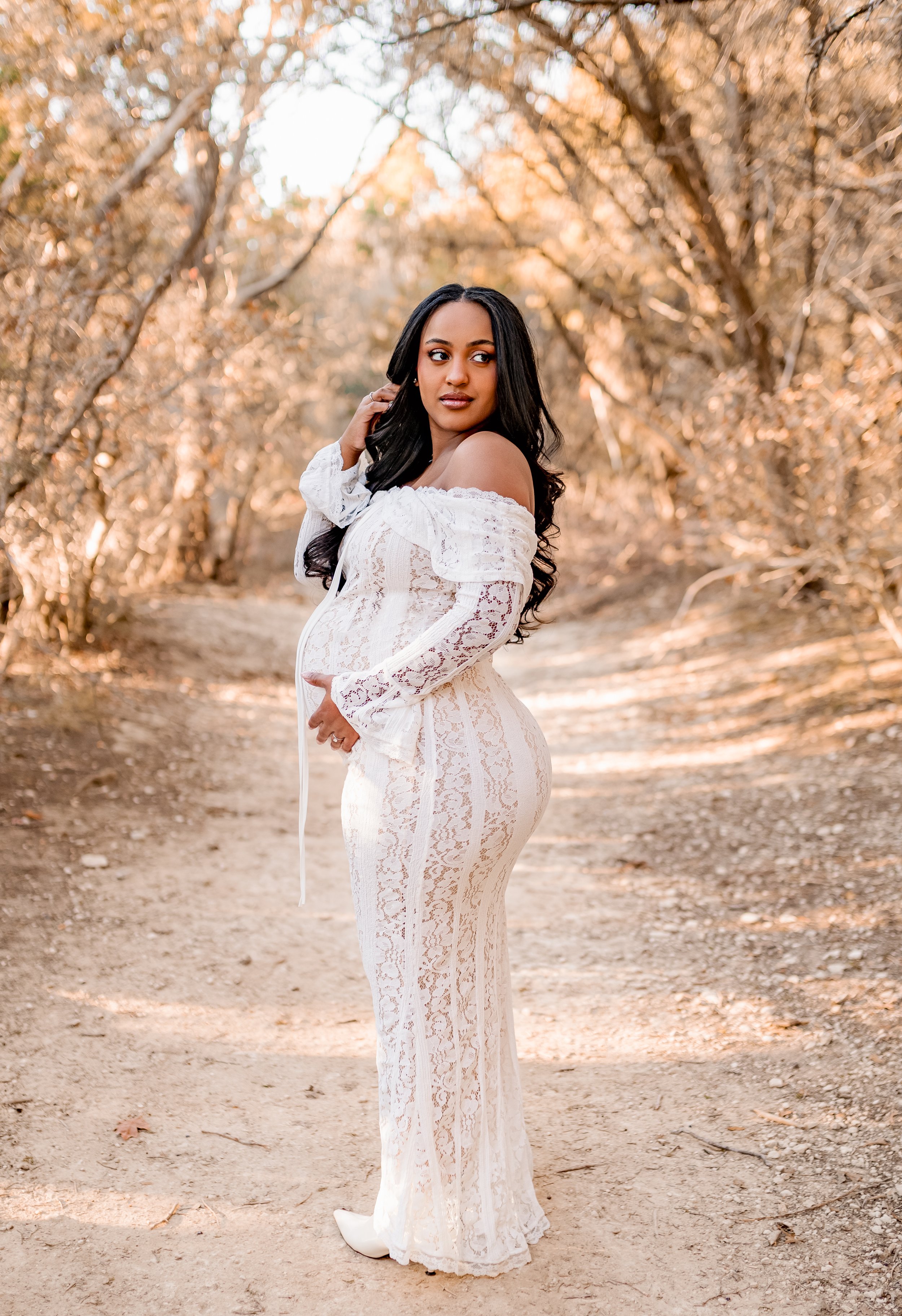 Expecting mother at a round rock park posing for maternity photos at golden hour