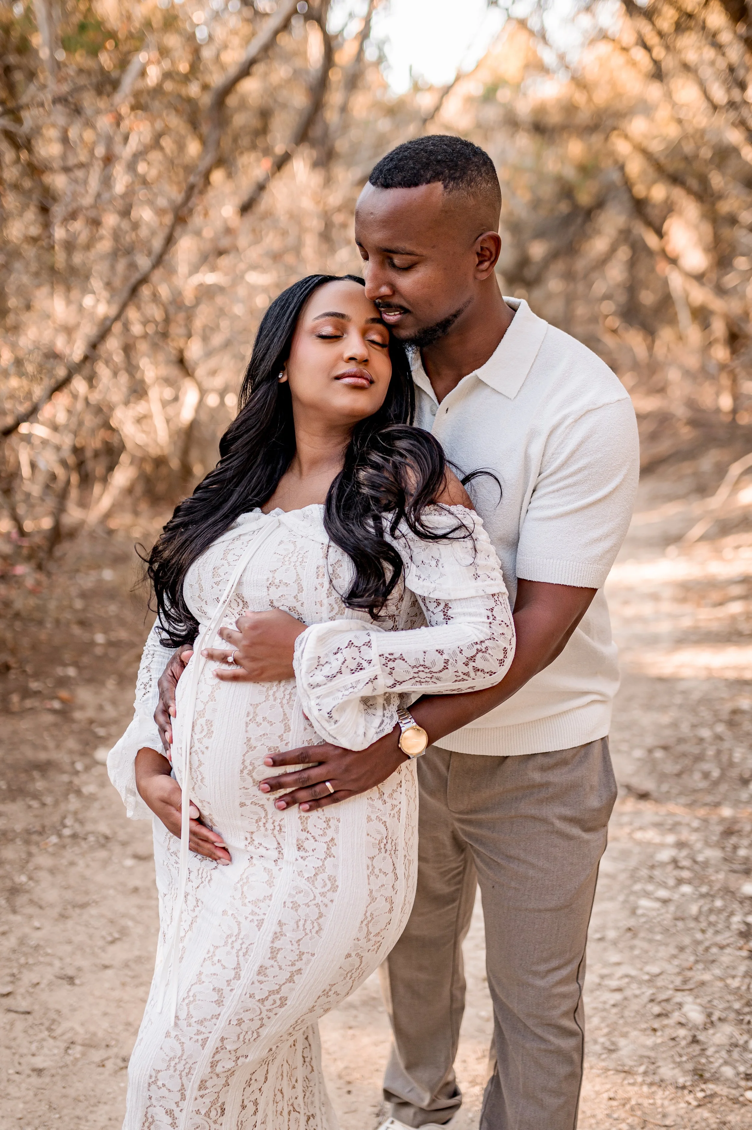 Couple hugging baby bump during a maternity shoot at a round rock park