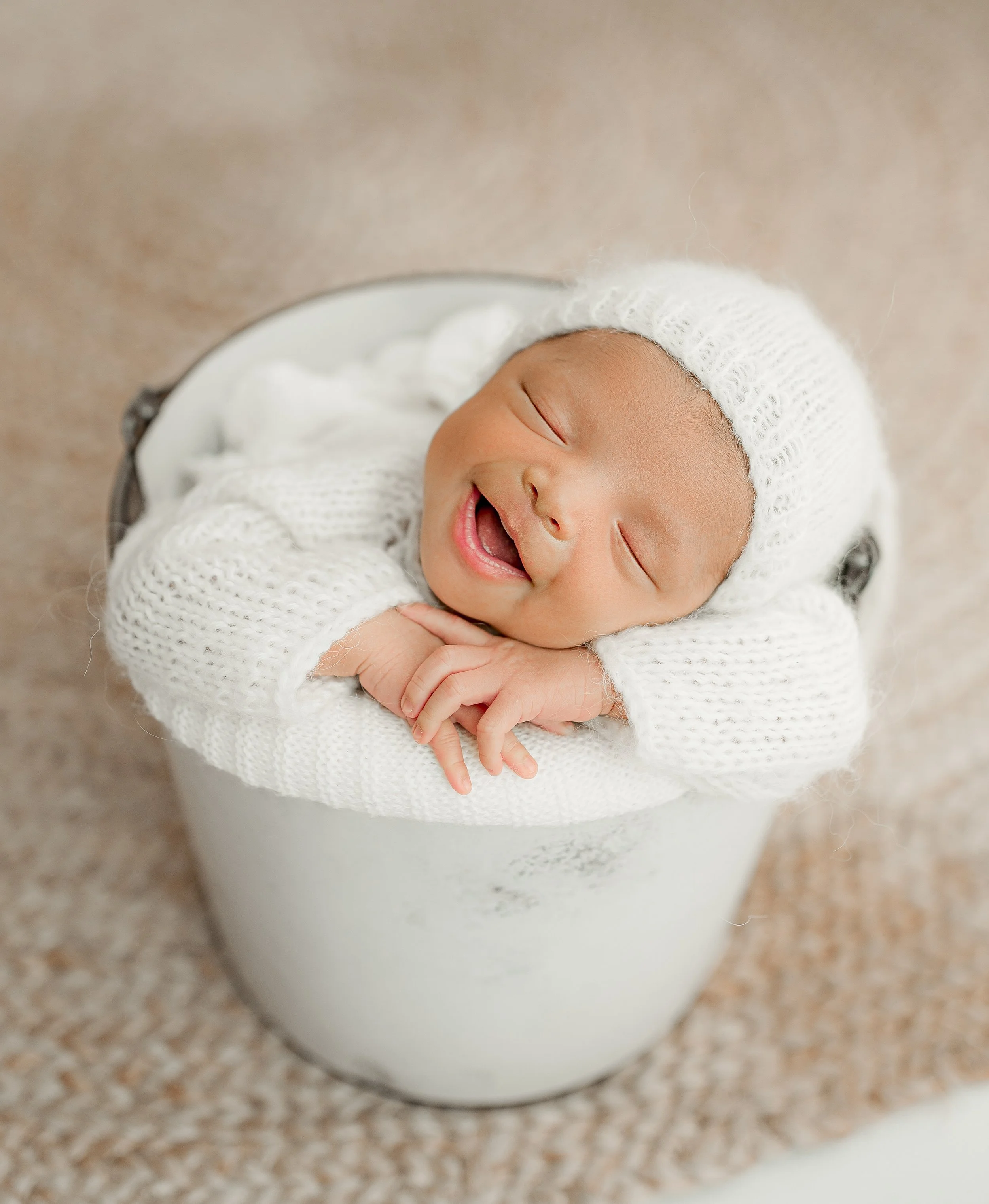 Comfortable newborn baby posed in a light Austin photography studio