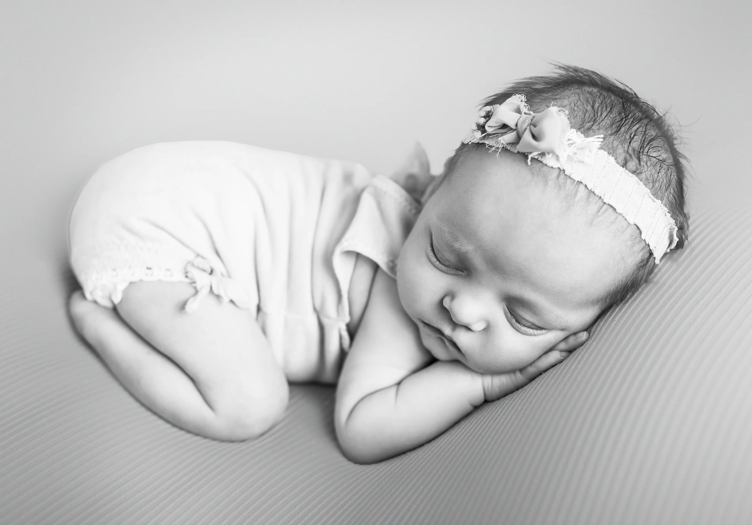 A posed newborn sleeping while being photographed in a Georgetown studio