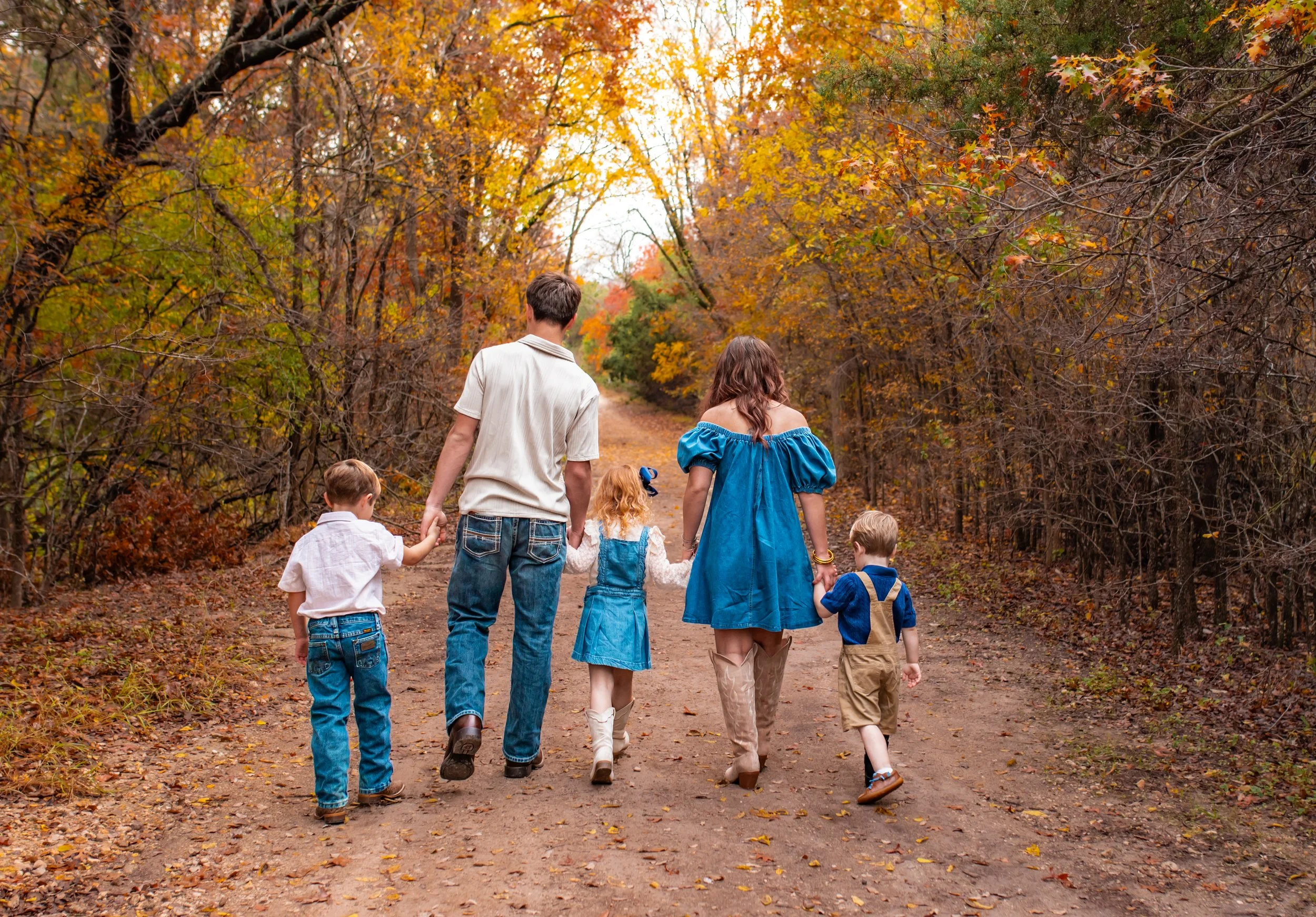 Siblings walking down trail during outdoor photos