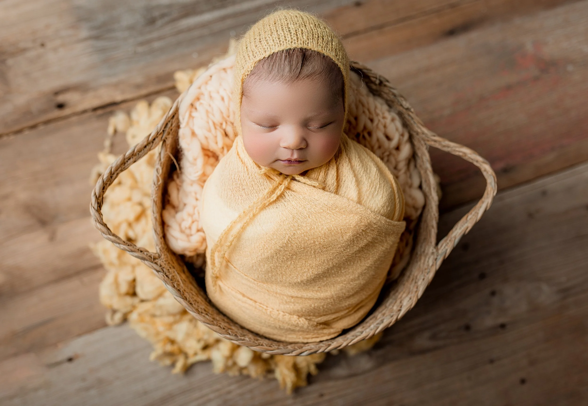 newborn baby wrapped in a basket for a newborn session in Round Rock