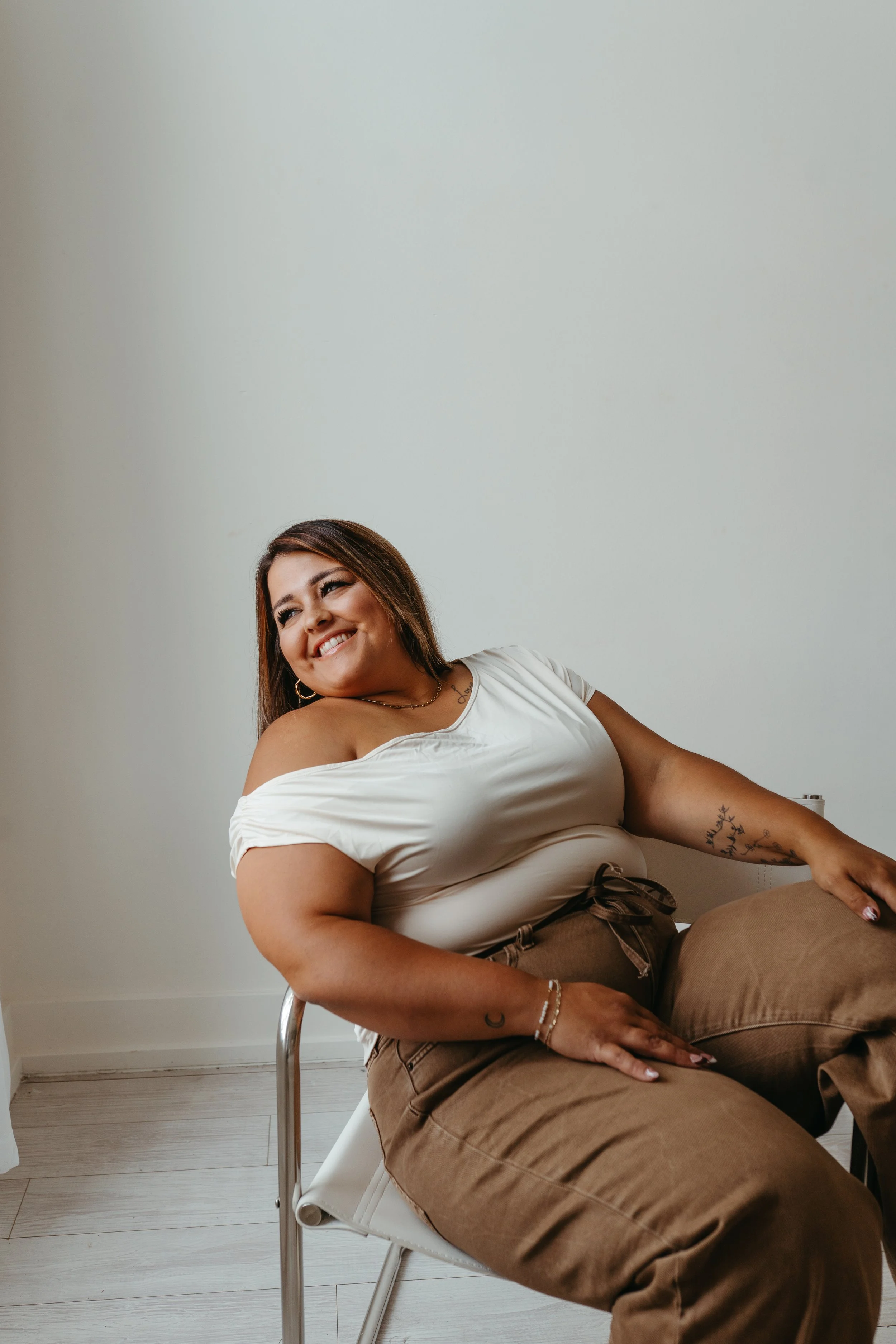 Hannah Schmidt the manager of Capitol Cryo Medspa is sitting in a chair smiling