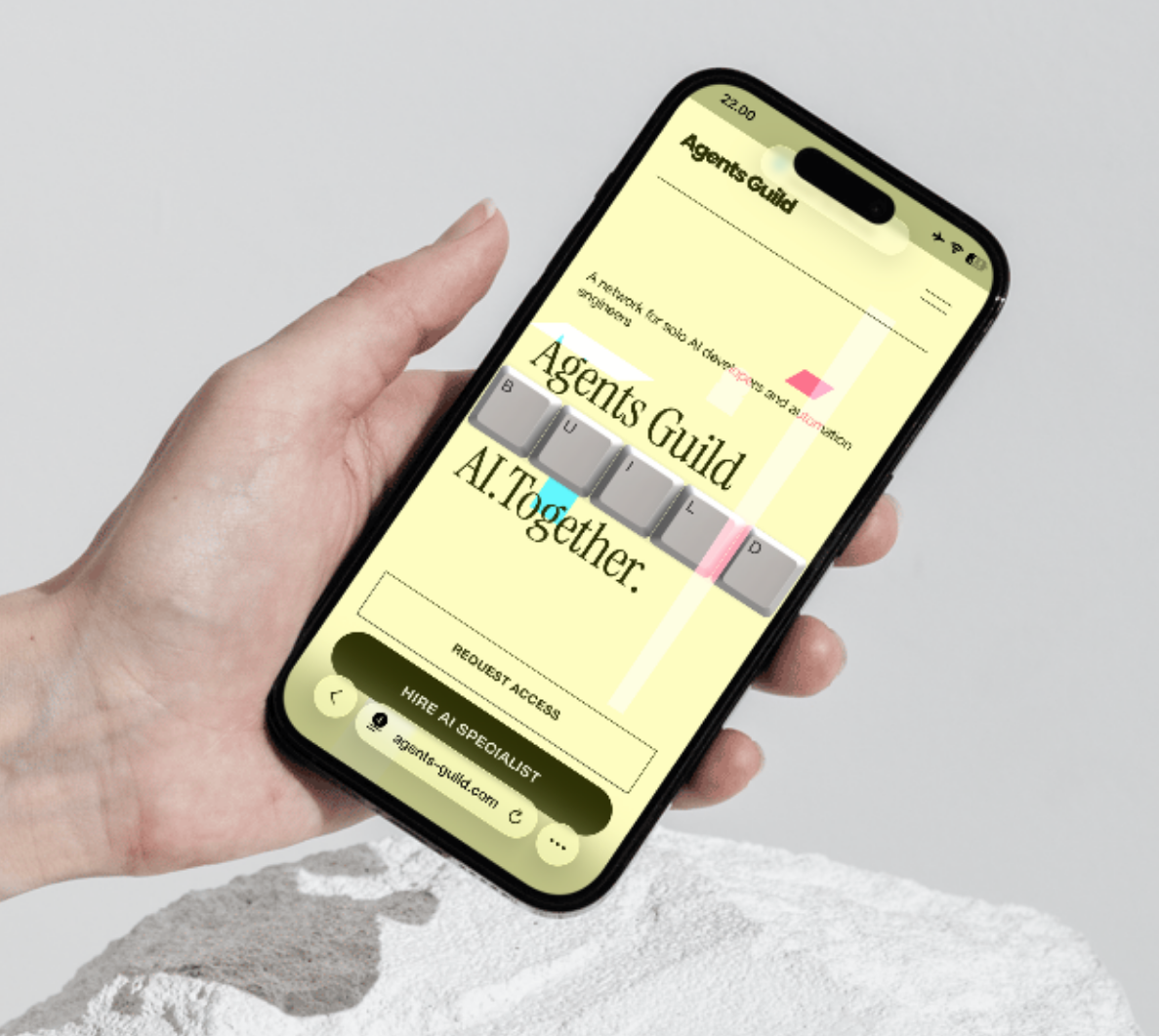 Hand holding a smartphone displaying a website for Agents Guide with a bright yellow background and black text.