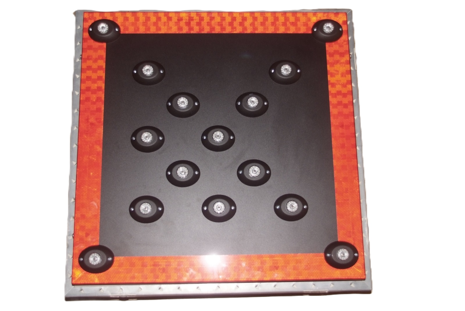 A square bounce pad with several suction cups or circular pads on its surface, surrounded by a red border with a yellowcheckered pattern.