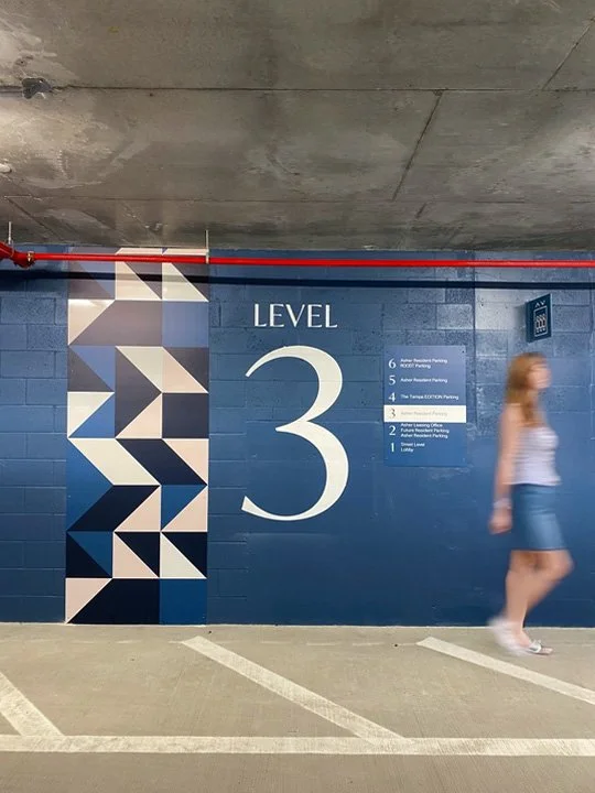 Sign indicating the parking garage level 3, with a woman walking past
