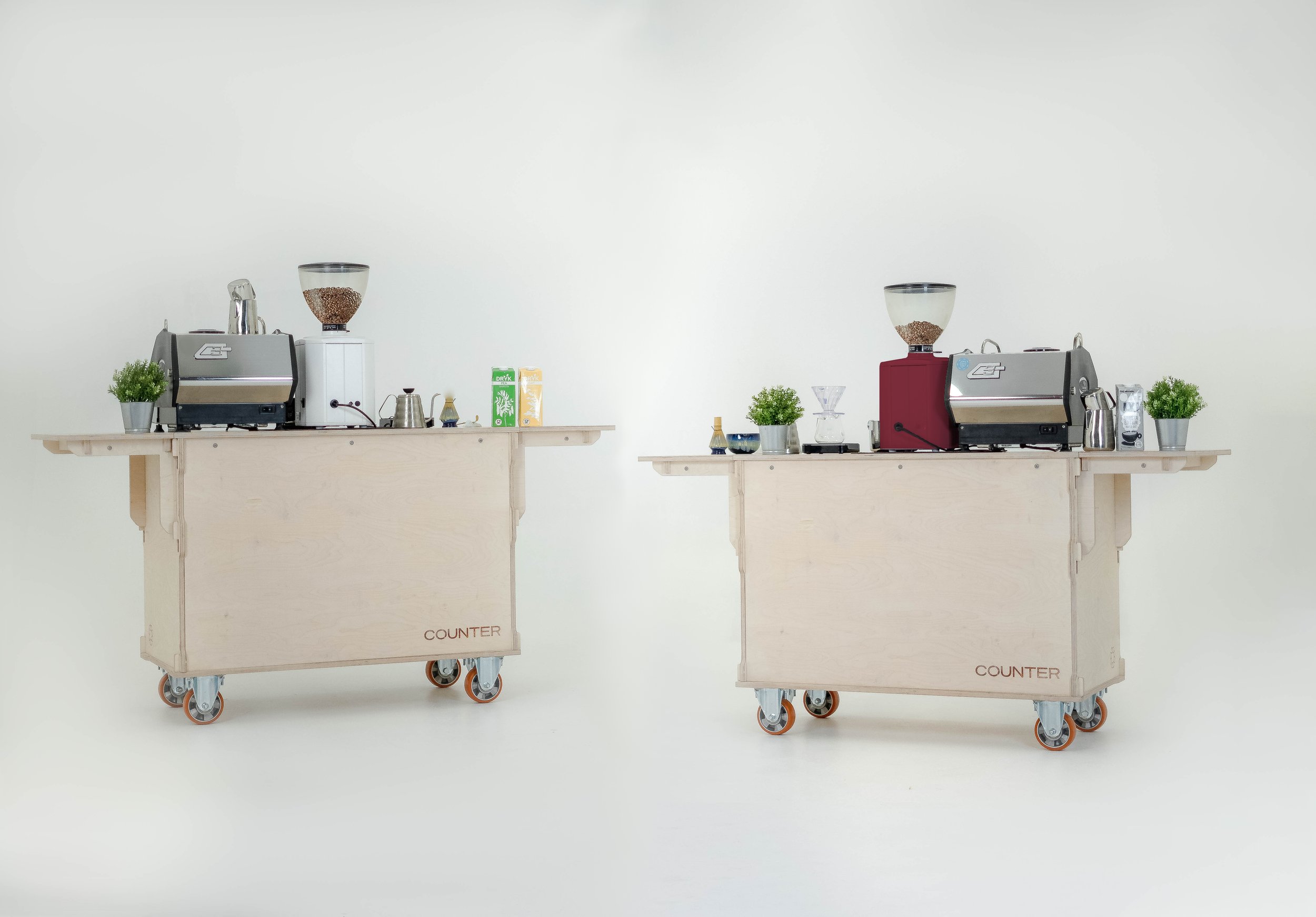 Two coffee beverage stations on mobile carts with coffee machines, grinders, cups, and small plants, set against a plain white background.