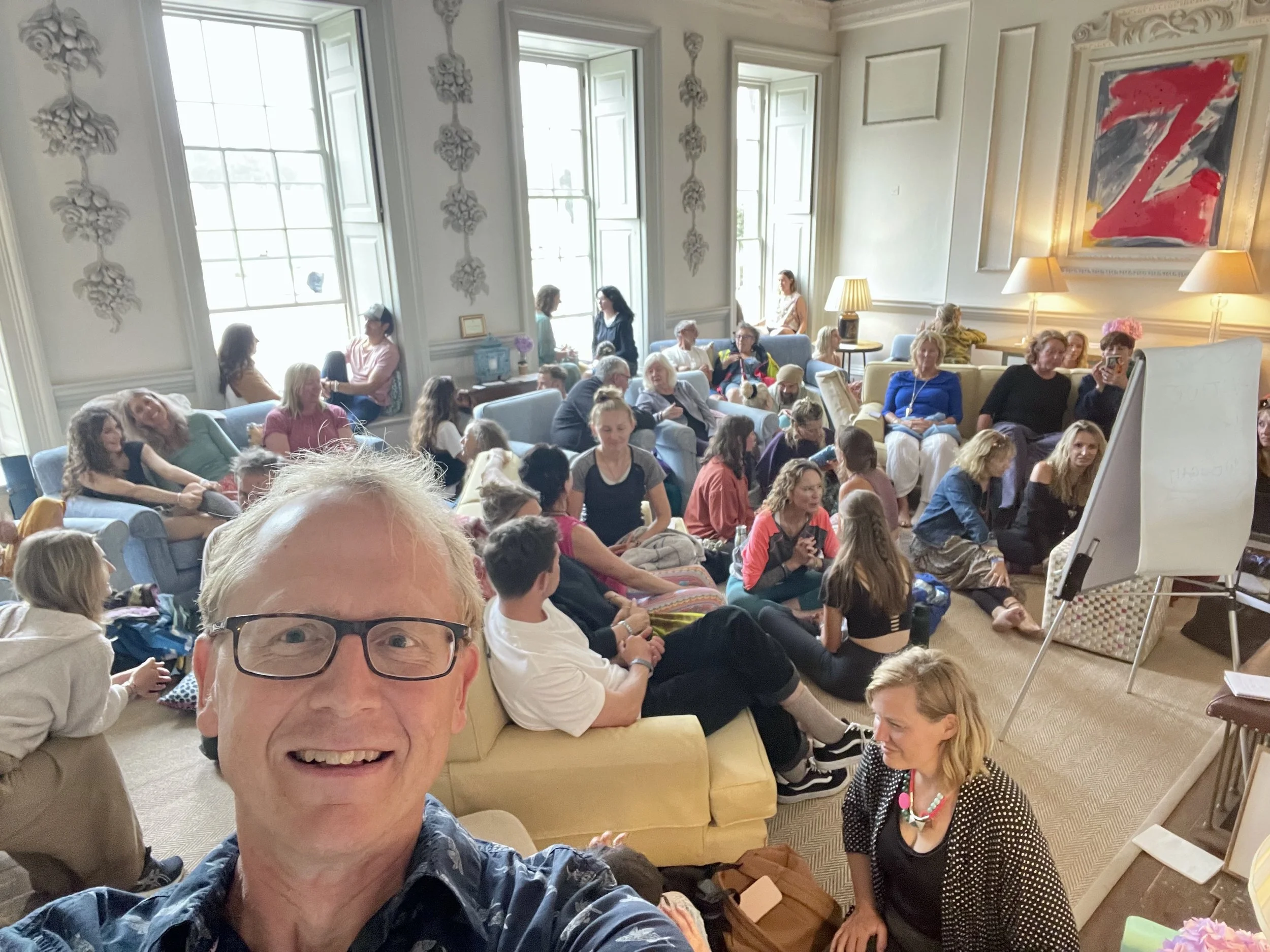 A group of people enjoying a hypnosis workshop in a beautiful country house living room