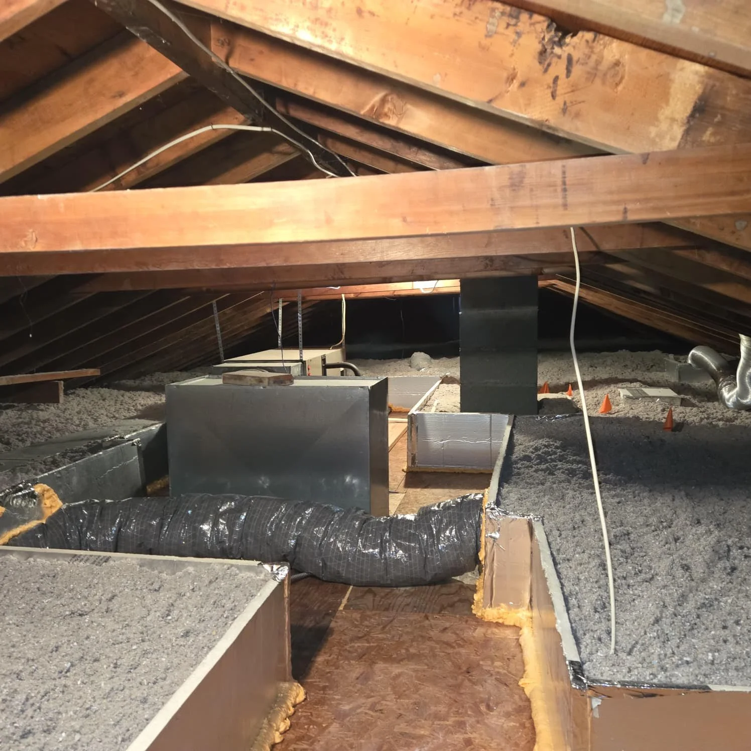 Insulation and ductwork installed in an attic space.