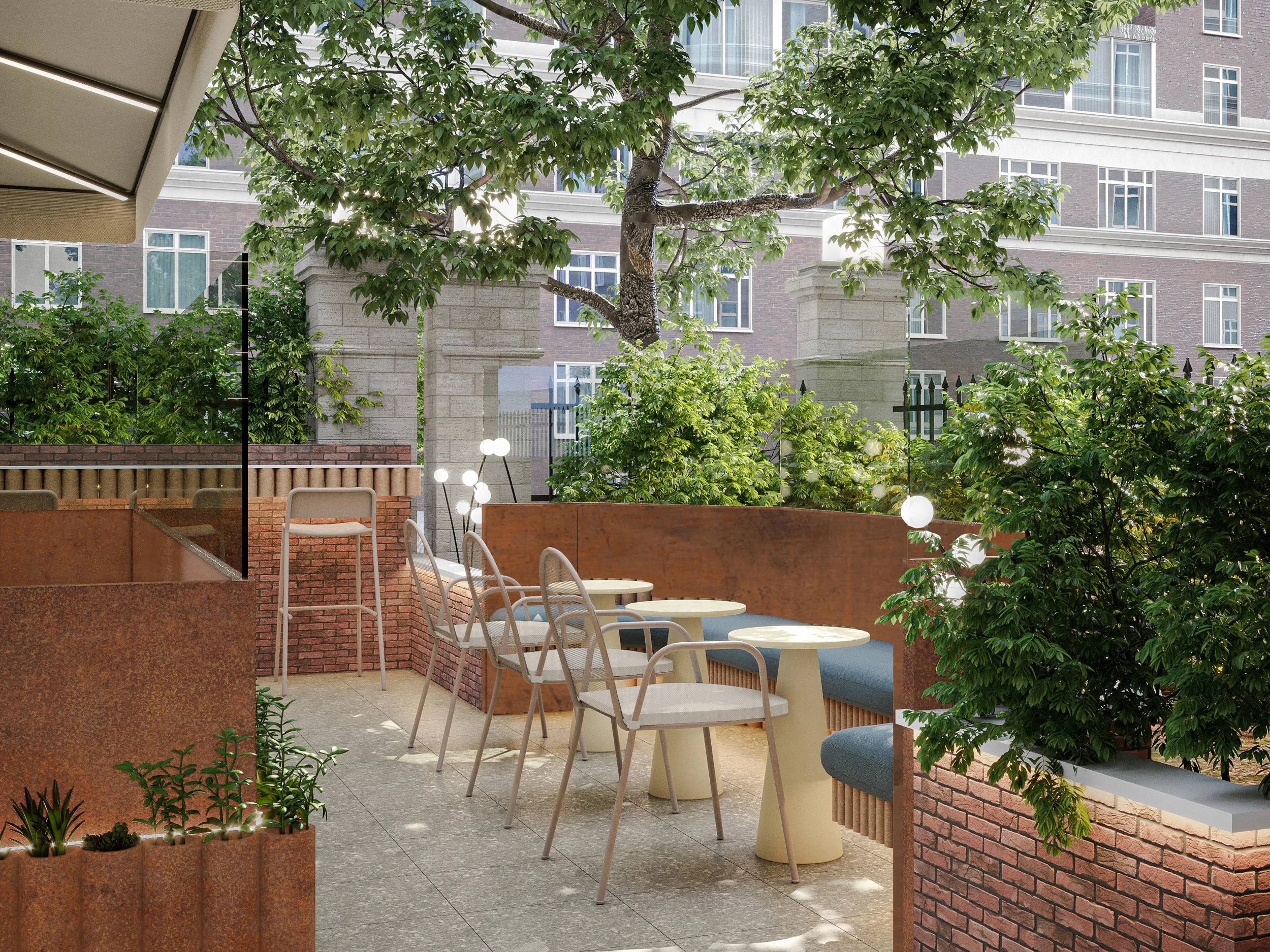 An outdoor patio with several white chairs and round tables, surrounded by brick walls and lush green trees, with a tall building in the background.