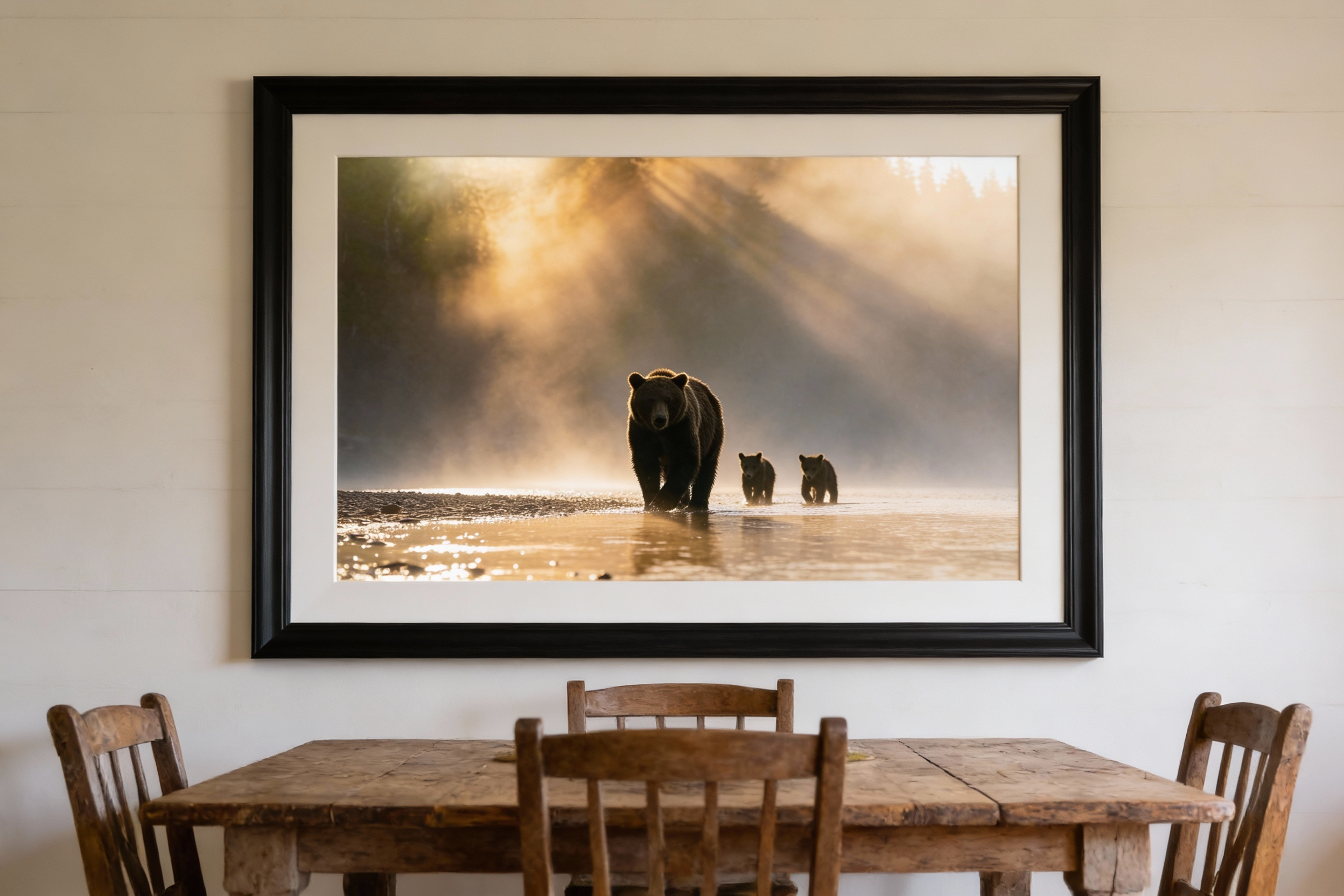 A grizzly bear mother and her cubs wade through the shallow waters of the Chilko River in British Columbia at sunrise. Golden light spills across the water's surface as the family moves together, the rugged riverbank and wilderness stretching out beh
