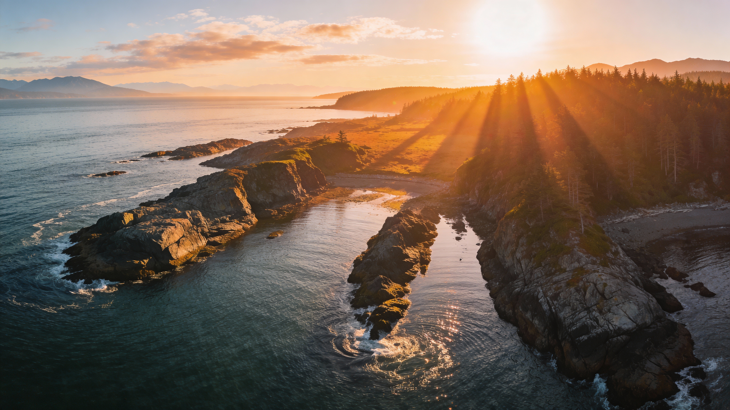 Sunset over a rocky coastline with old-growth trees and ocean waves on the British Columbia coast