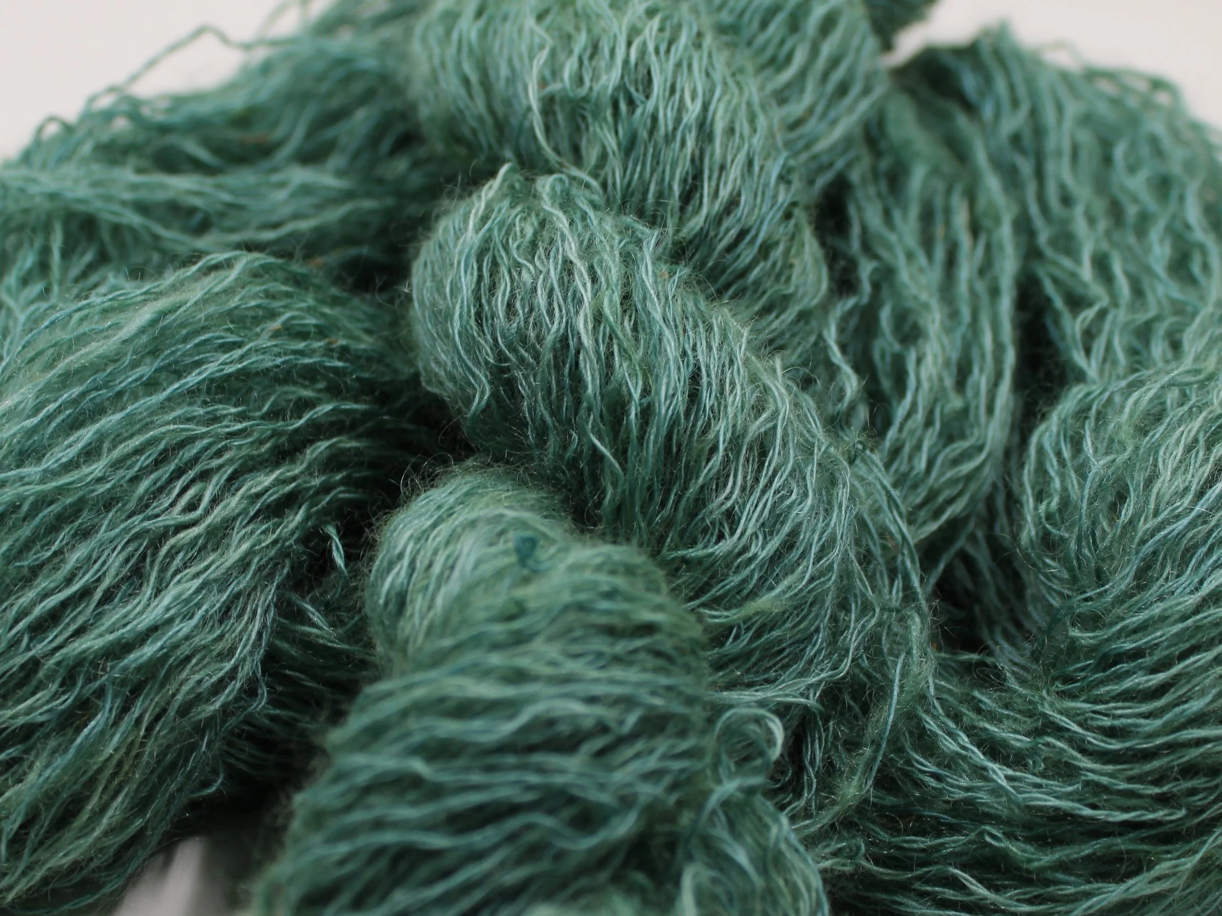 Close-up photograph of tangled green yarn or thread.