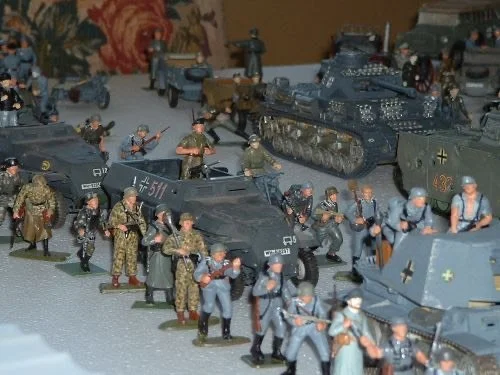 Assault troops gather at the edge of the ruins, faces hidden beneath helmets and frost, orders passed quietly hand to hand.