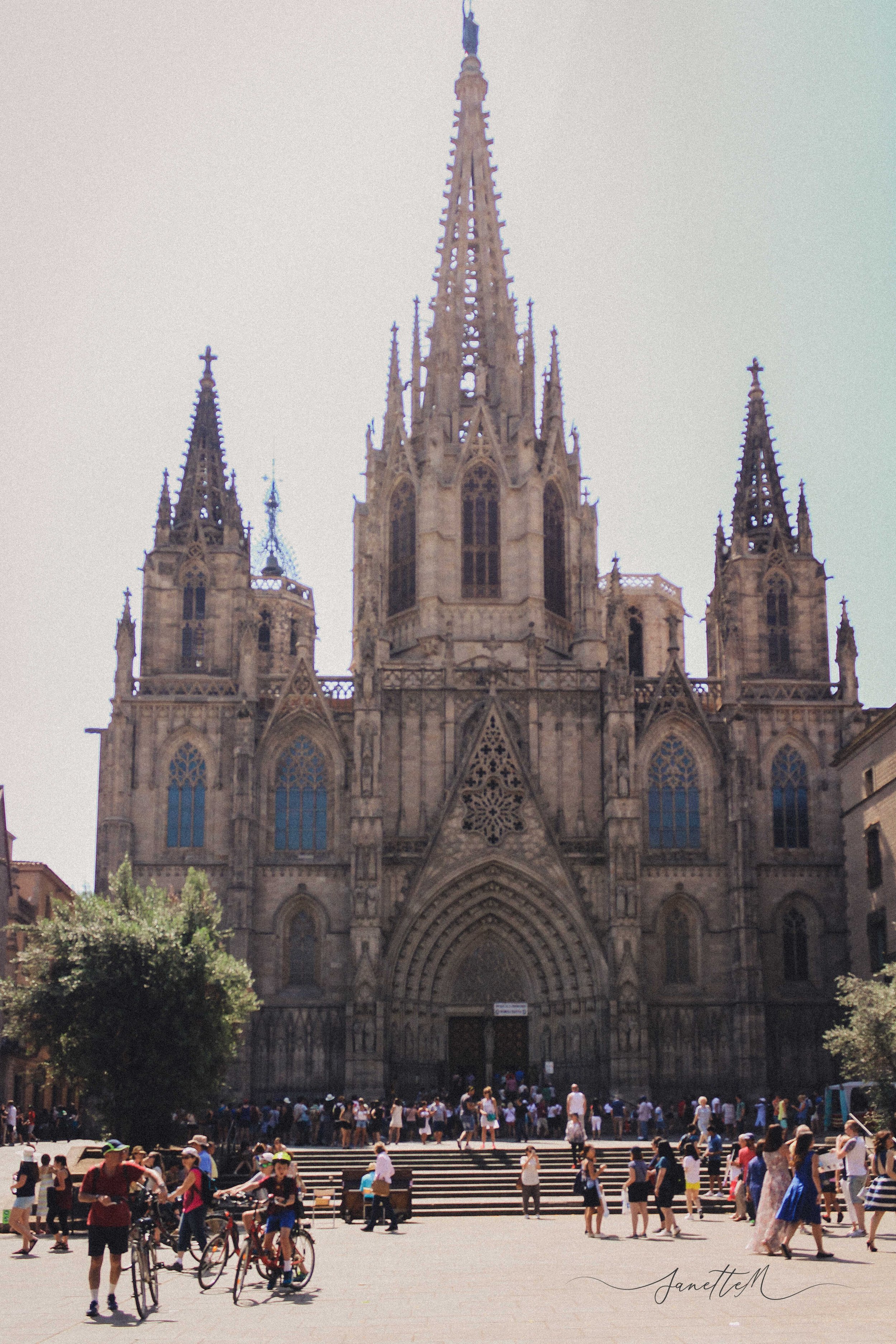 Barcelona - Catedral gótica en un día soleado con muchas personas y niños en la plaza frente a la entrada.