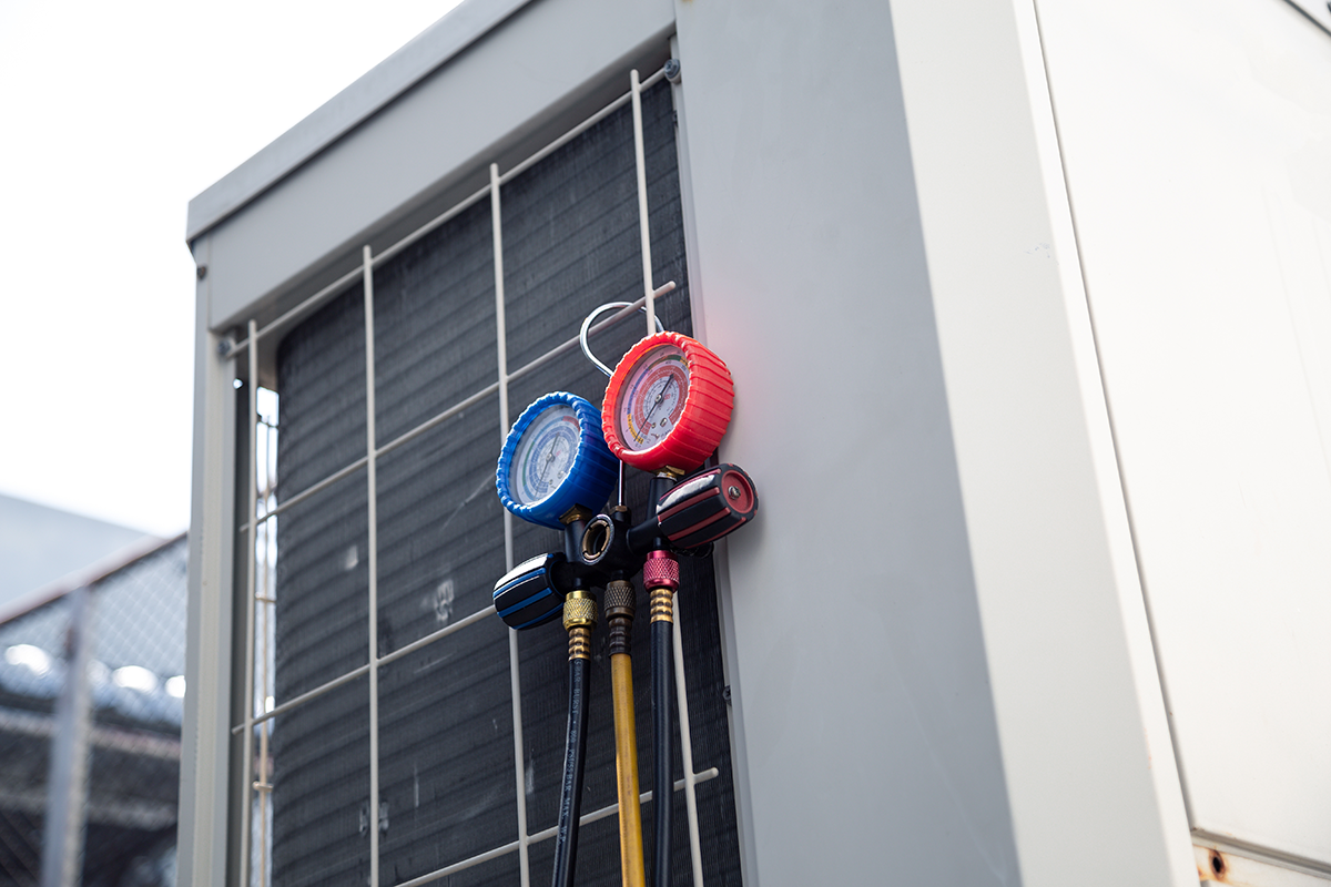 HVAC unit with gauges and hoses attached for maintenance or repair.