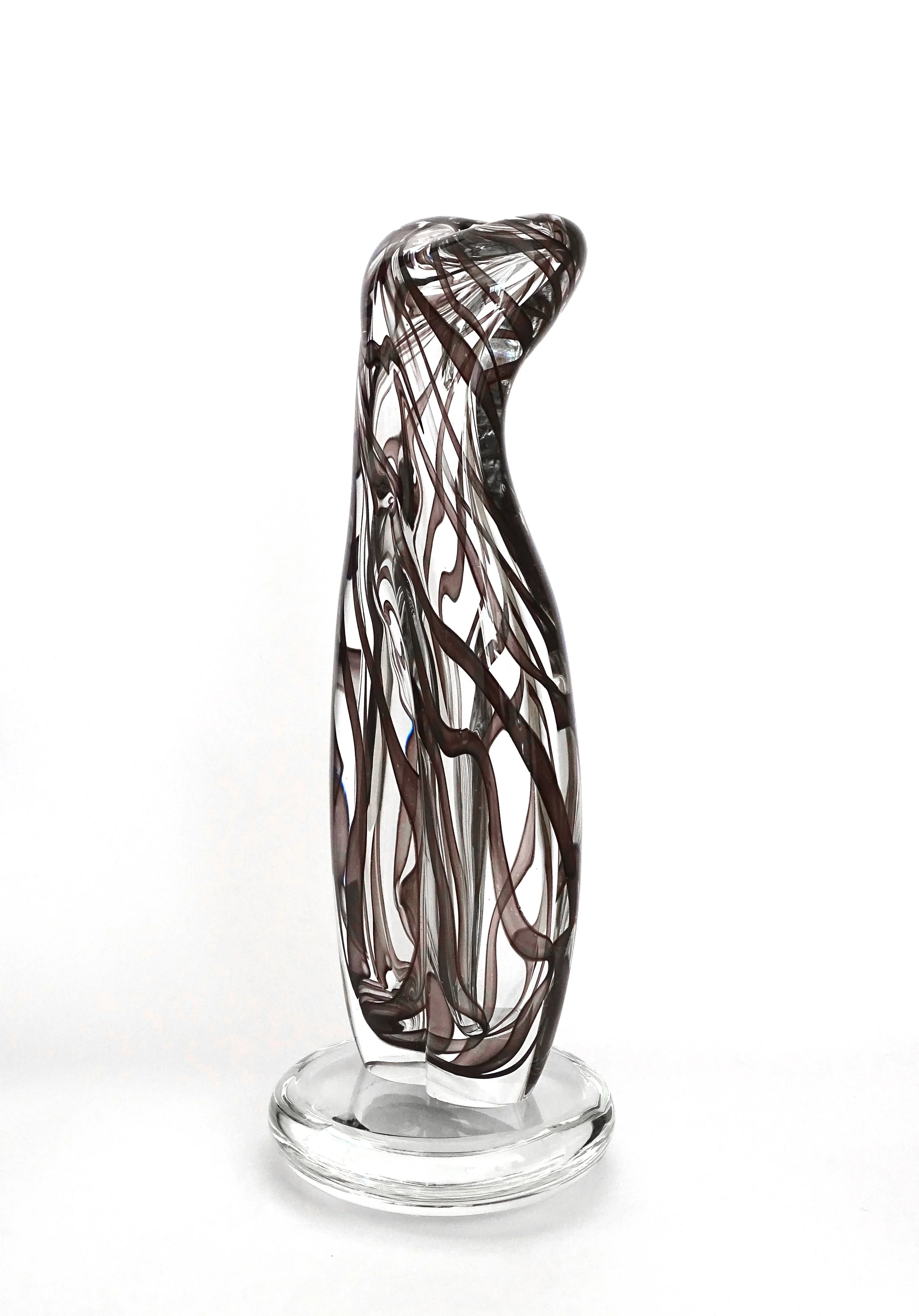 Glass sculpture with intricate swirling black and clear patterns on a transparent base against a white background.