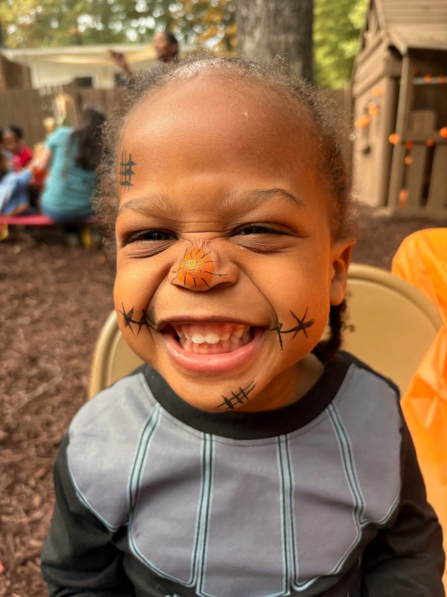 A 3 year old girl smiling after getting her face painted at the HLC Fall Festival 2025