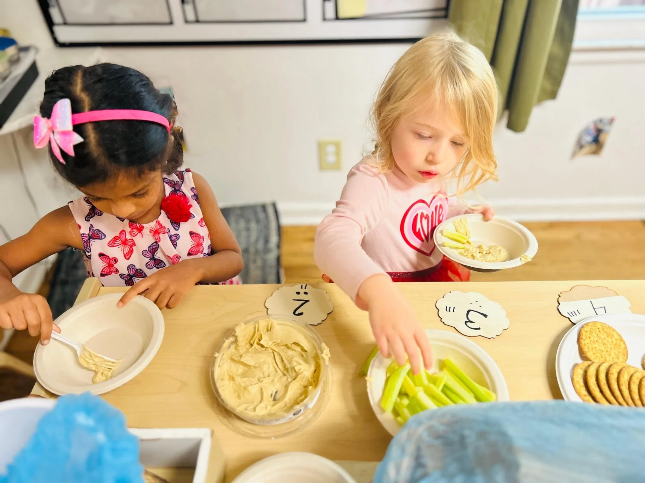 Two preschool girls participating in a food-based activity