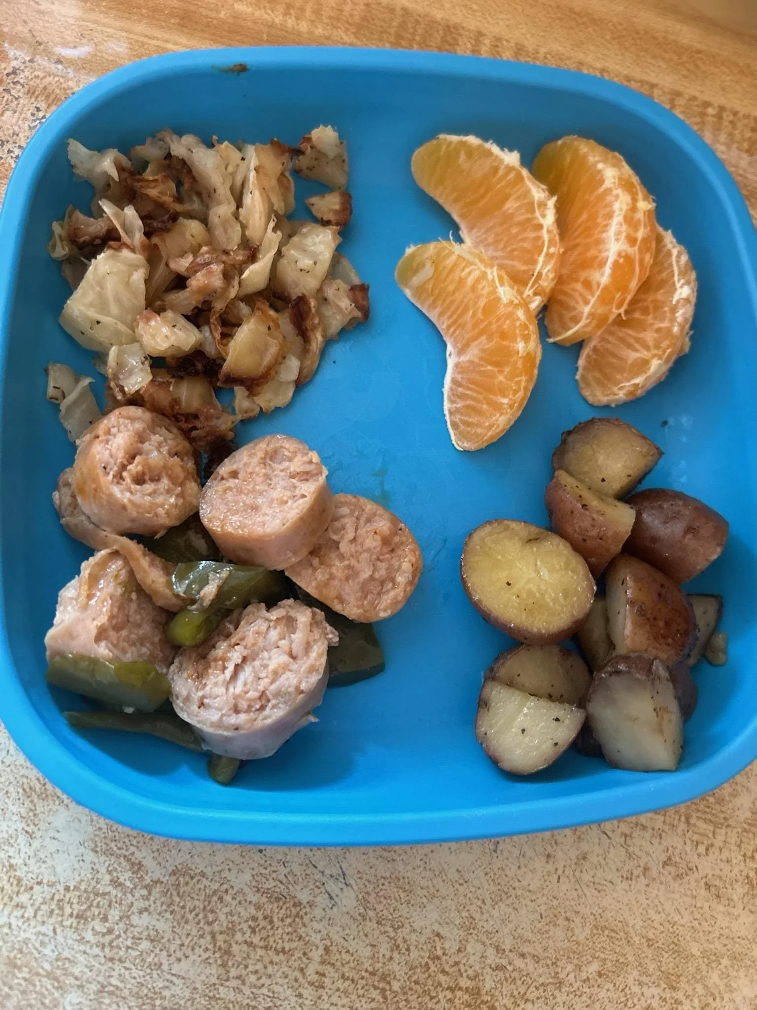 Sausage and pepers, potatoes, and oranges