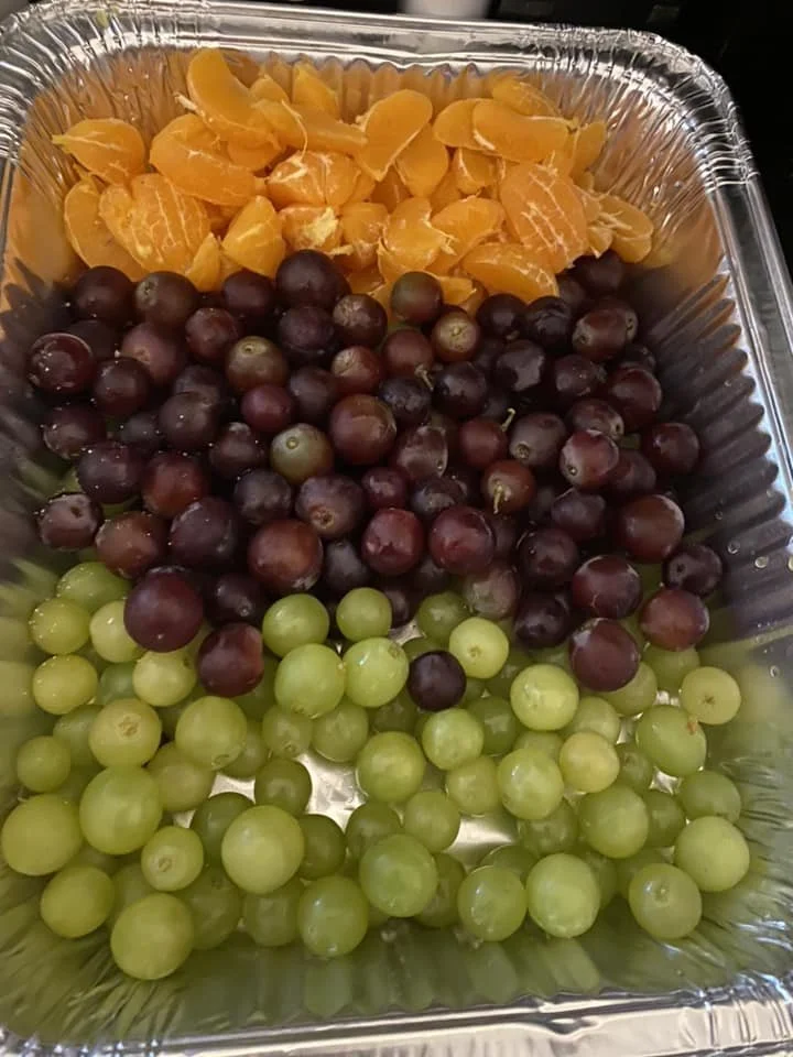 Orange slices with red and green grapes