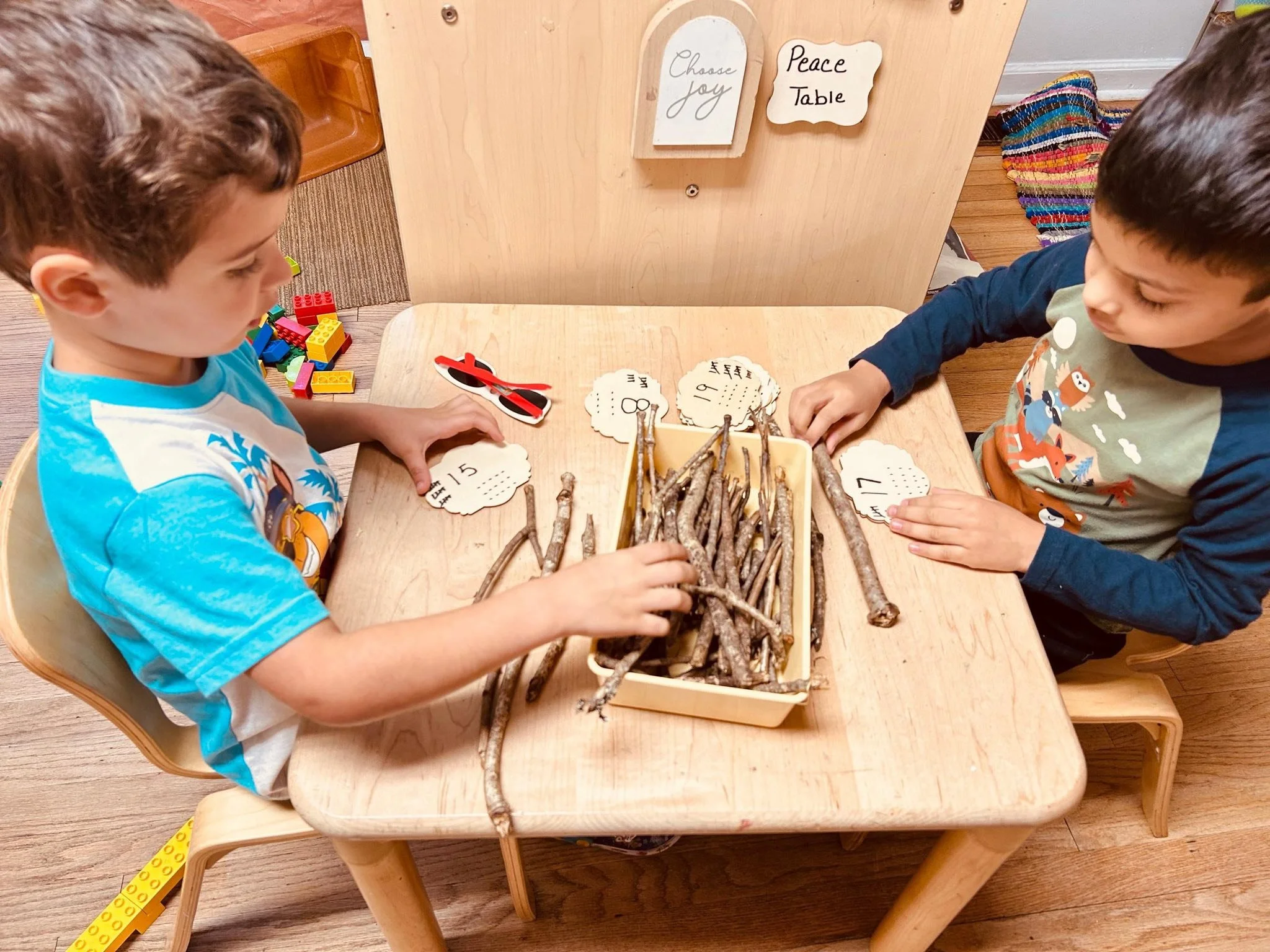 Two prechool boys participating in an activity involving sticks