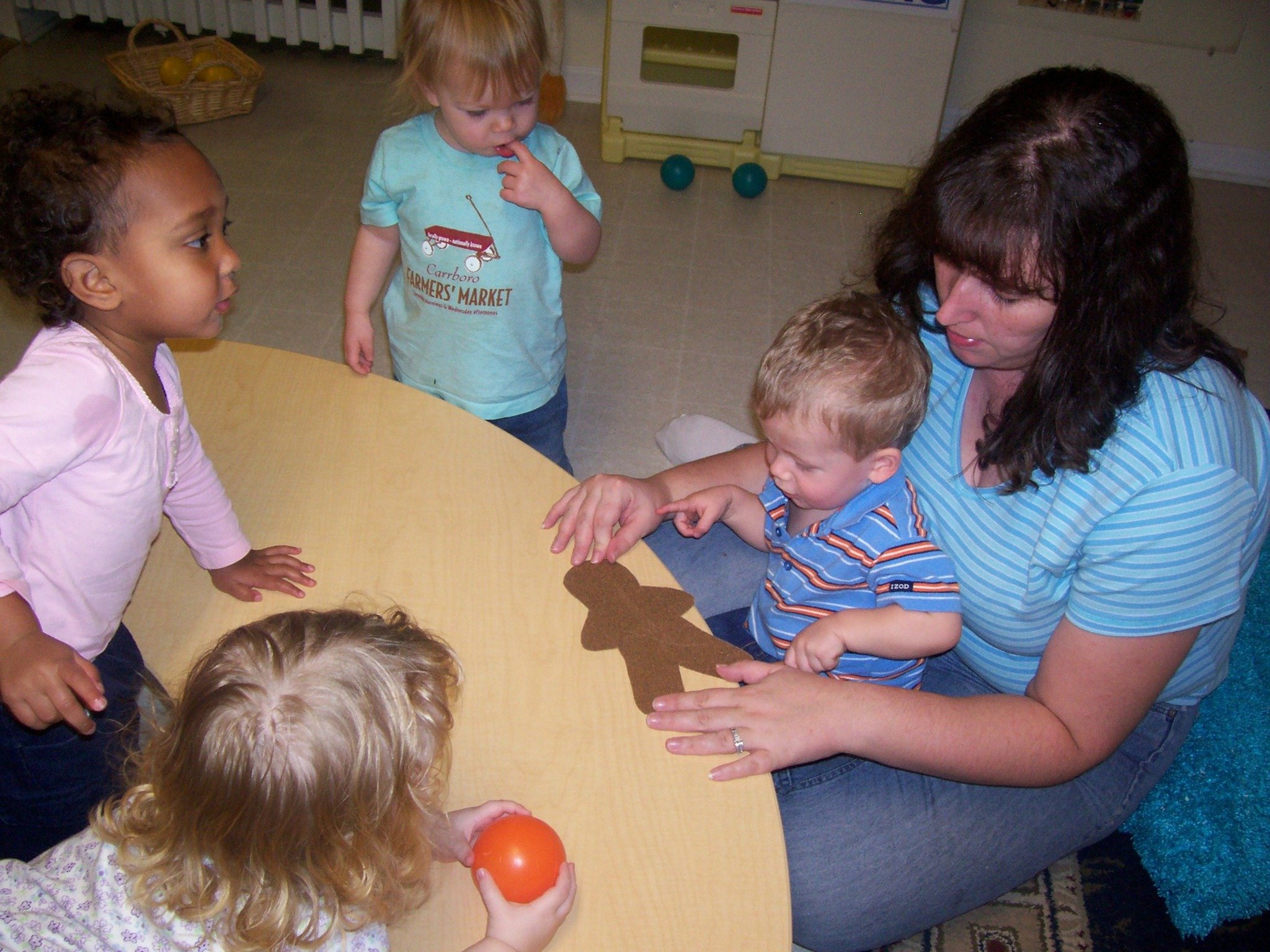Mrs. Ginger doing an activity with 2 and 3 year olds