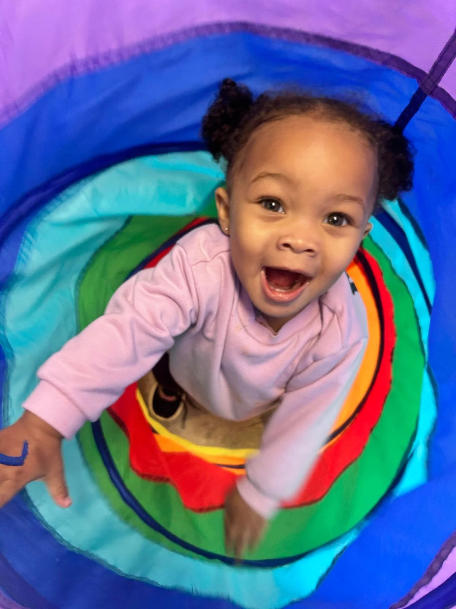A 3 year old climbing through a tunnel