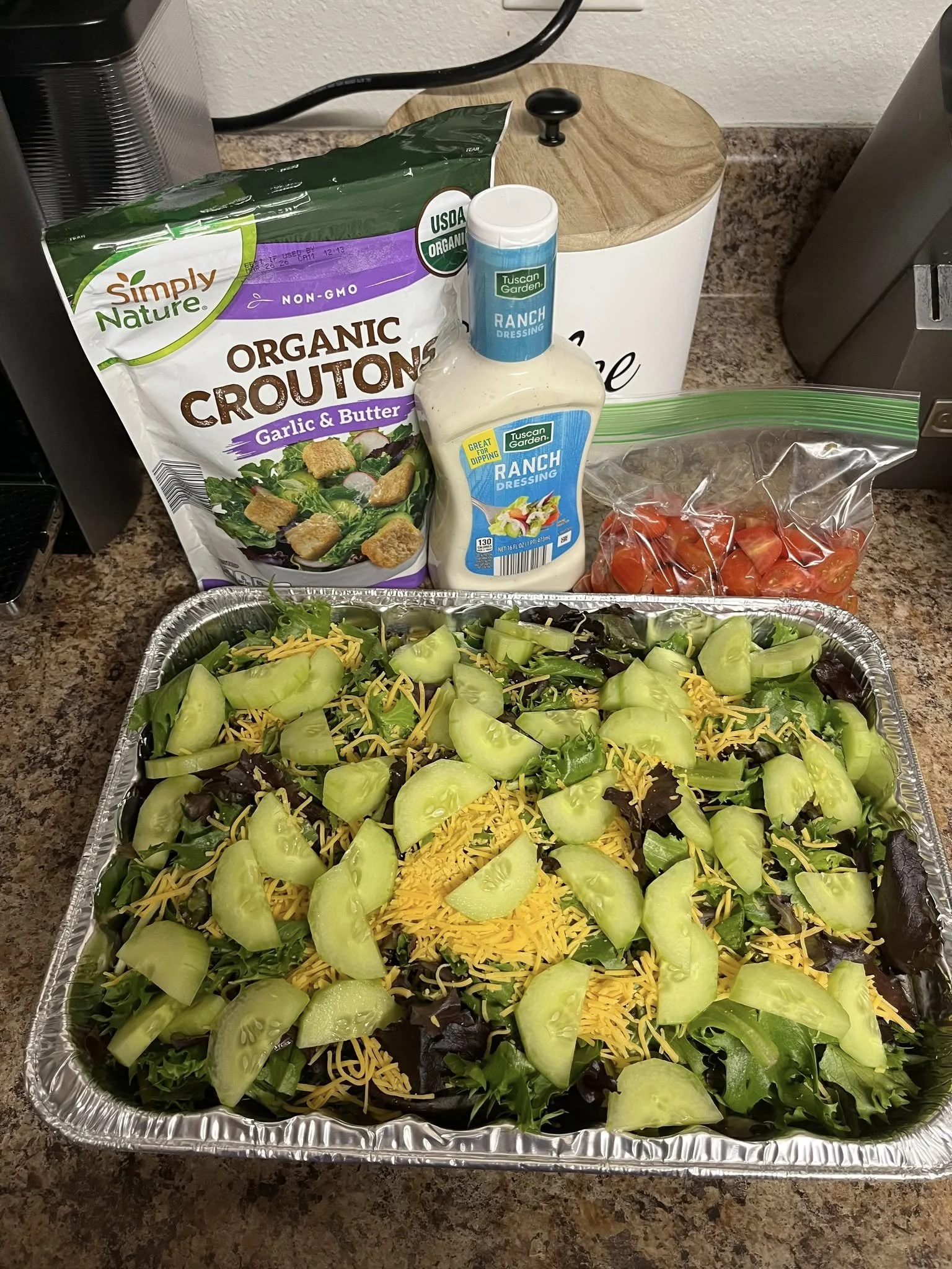 A fresh salad with cucumbers cheese, tomatoes, croutons, and ranch dressing 