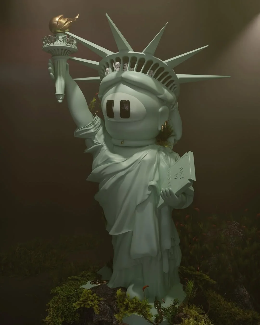 A sculpture of the Statue of Liberty with a human face and hands, holding a book in one hand and a torch in the other. The face is humorous and cartoonish, with wide eyes and a goofy expression. The sculpture is in a dark environment with some foliage at the base.