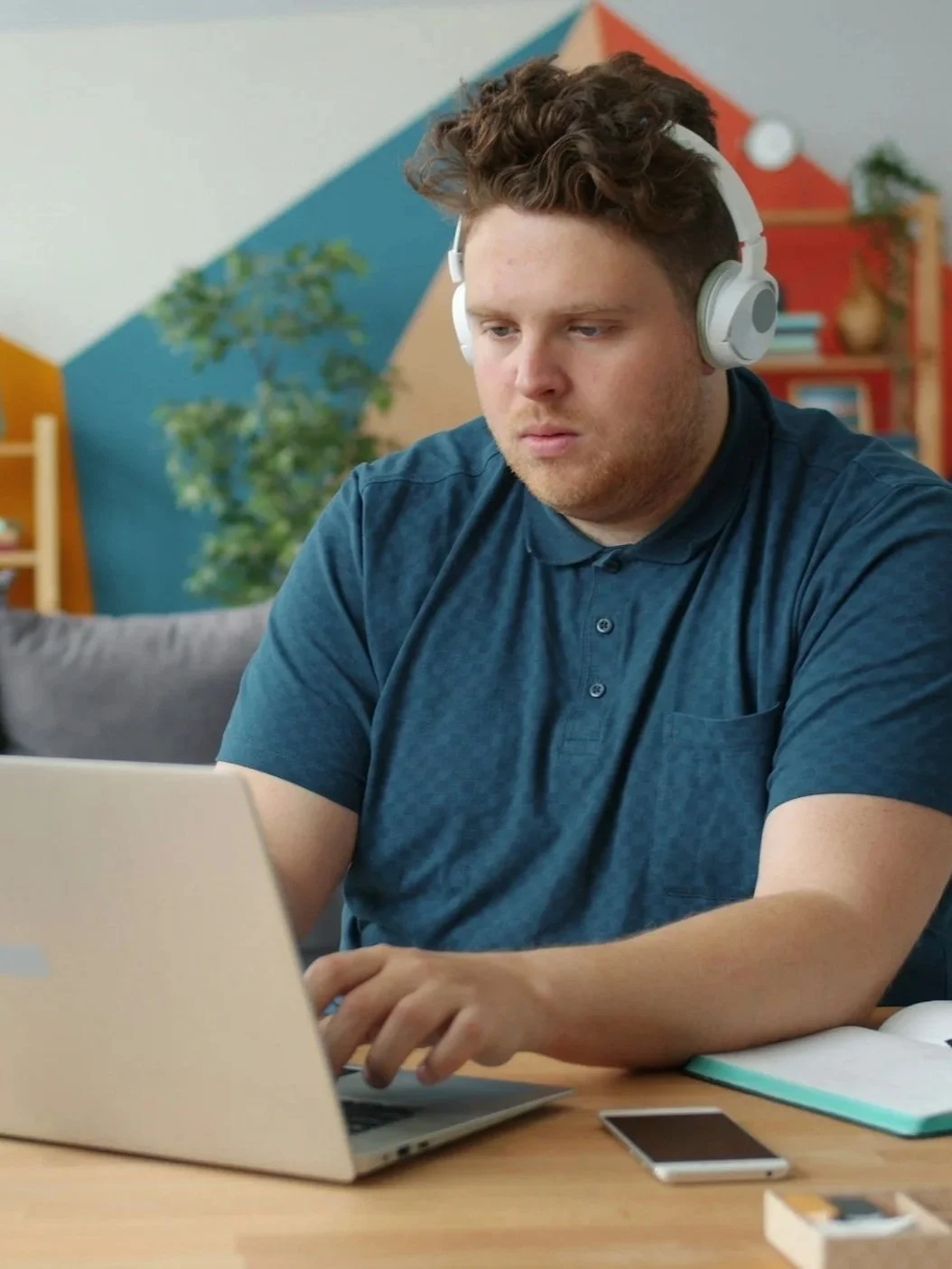 man sitting at a laptop wearing headphones