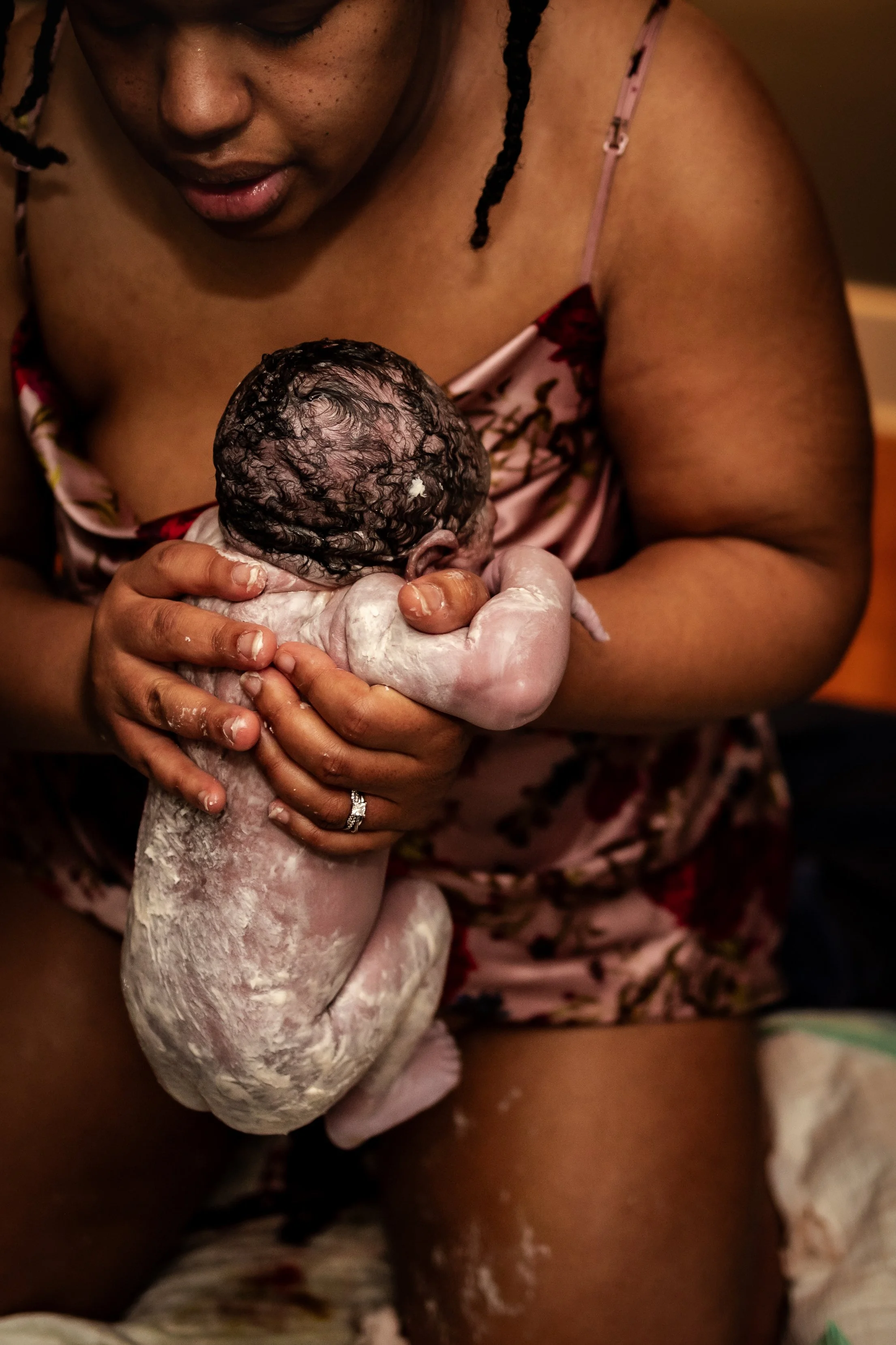 A woman holding a newborn baby during or after childbirth.