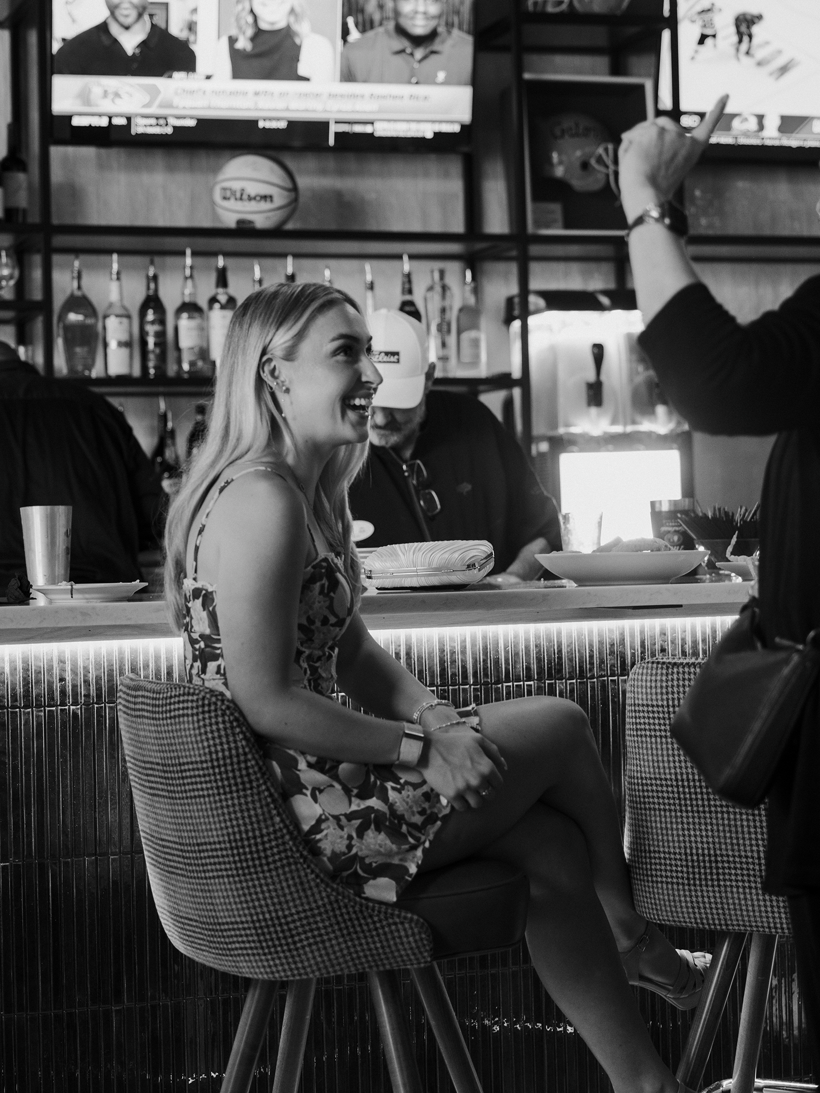 Guests enjoying a lively evening at the bar inside Roosevelts Restaurant & Bar at Live Oaks Golf Club in Brandon, Mississippi. A welcoming sports bar atmosphere with craft drinks, great company, and big screens overhead.