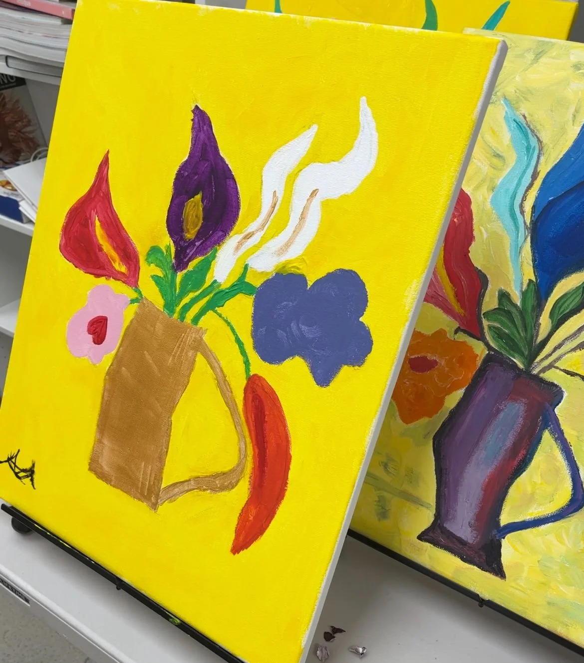 Bright yellow background with a colorful, abstract painting of a flower arrangement in a brown pitcher, featuring red, purple, pink, blue, and orange flowers with green leaves.