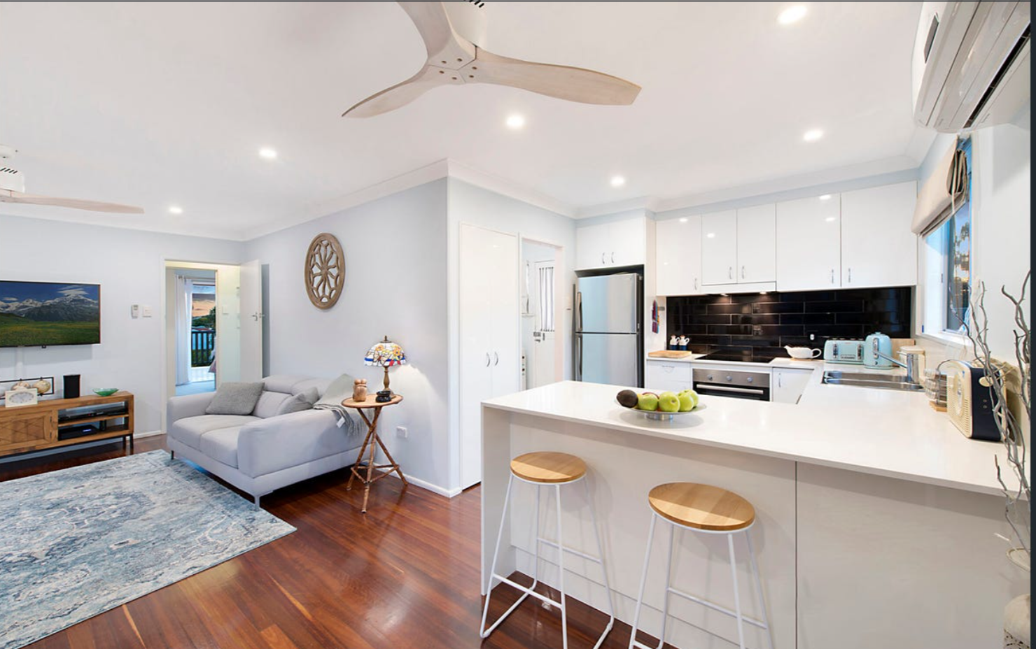 Open-plan kitchen and living space with island bench, modern finishes and timber floors