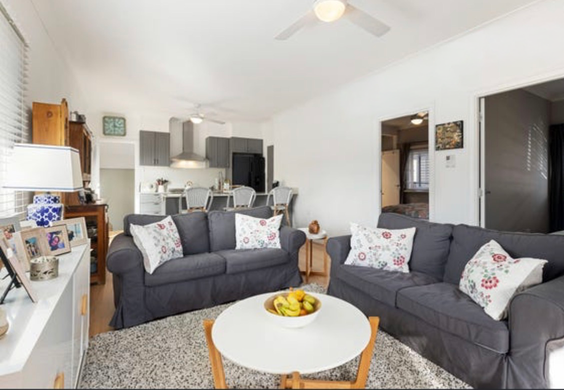 Open-plan living space with grey sofas flowing into modern kitchen and dining area
